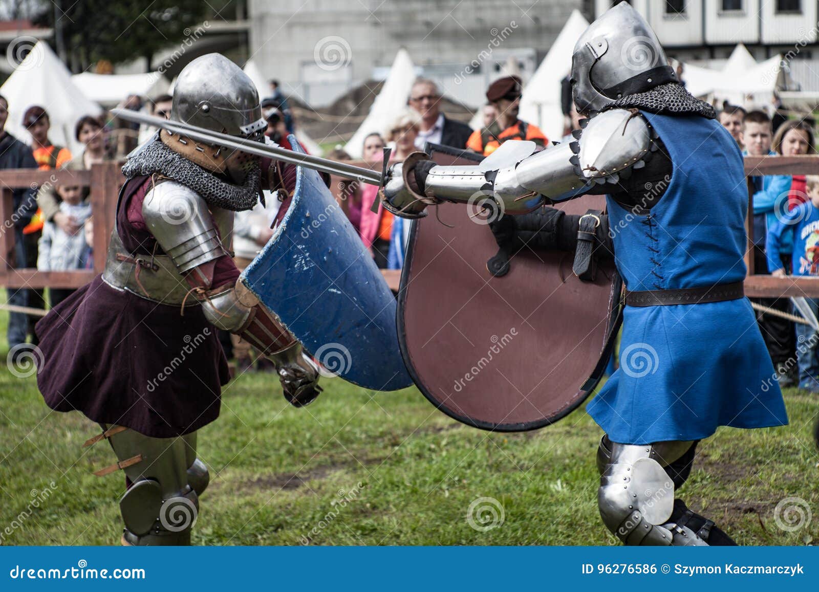 Two knights in armor fighting a duel with lances in a