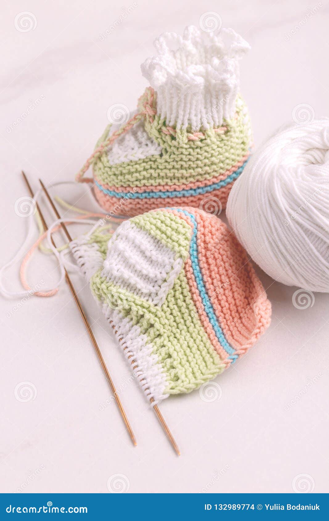 Knitted Baby Booties With Yarn And Needles Stock Photo