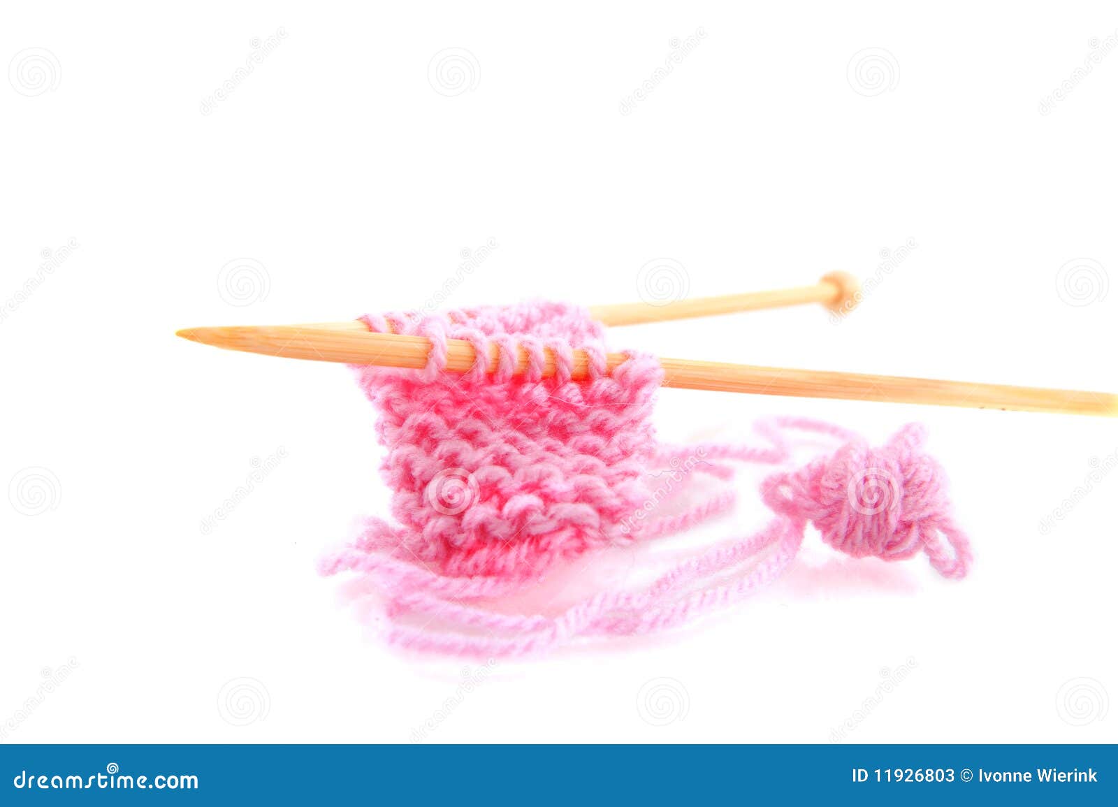 Knitting with pink wool and wooden needles