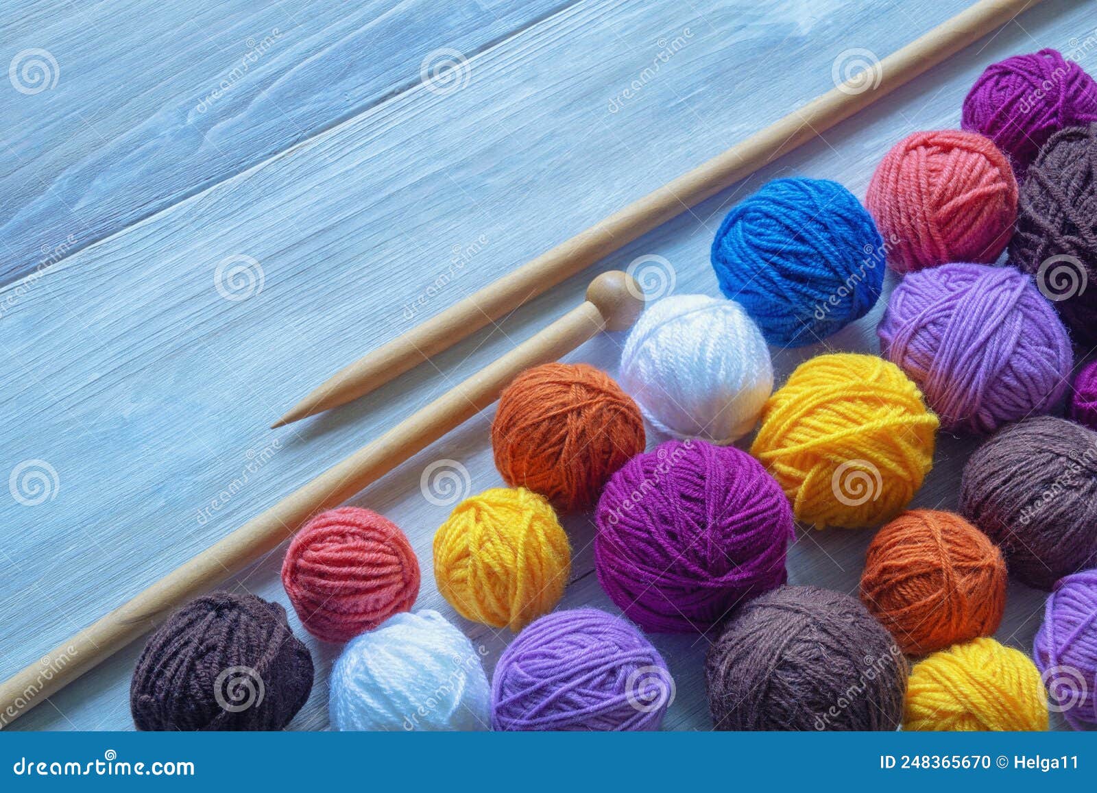Colorful Balls of Wool and Knitting Needles on Rustic Table. Space for