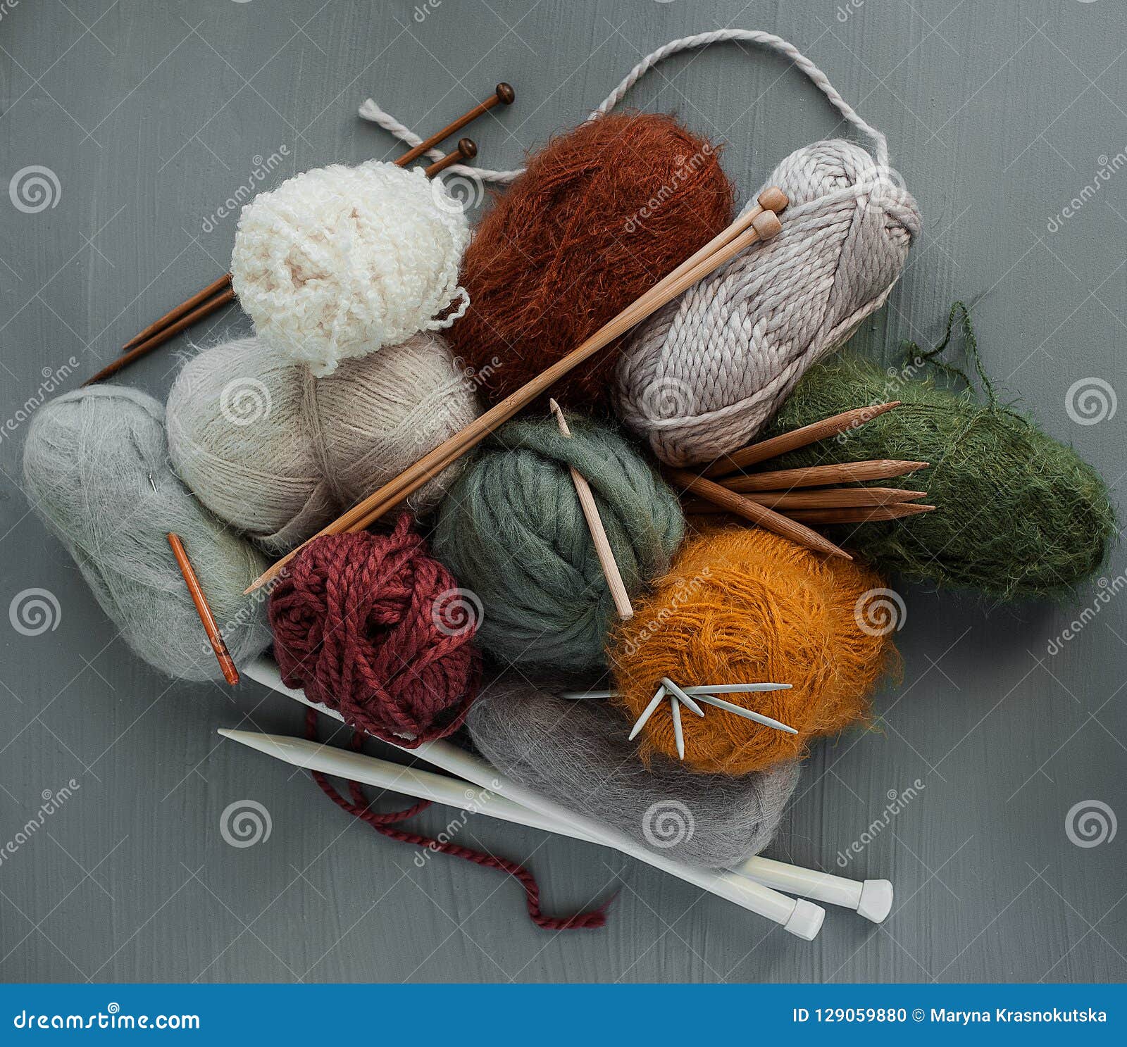 Knitting Yarns, Hooks and Knitting Needles on Grey Background. Stock