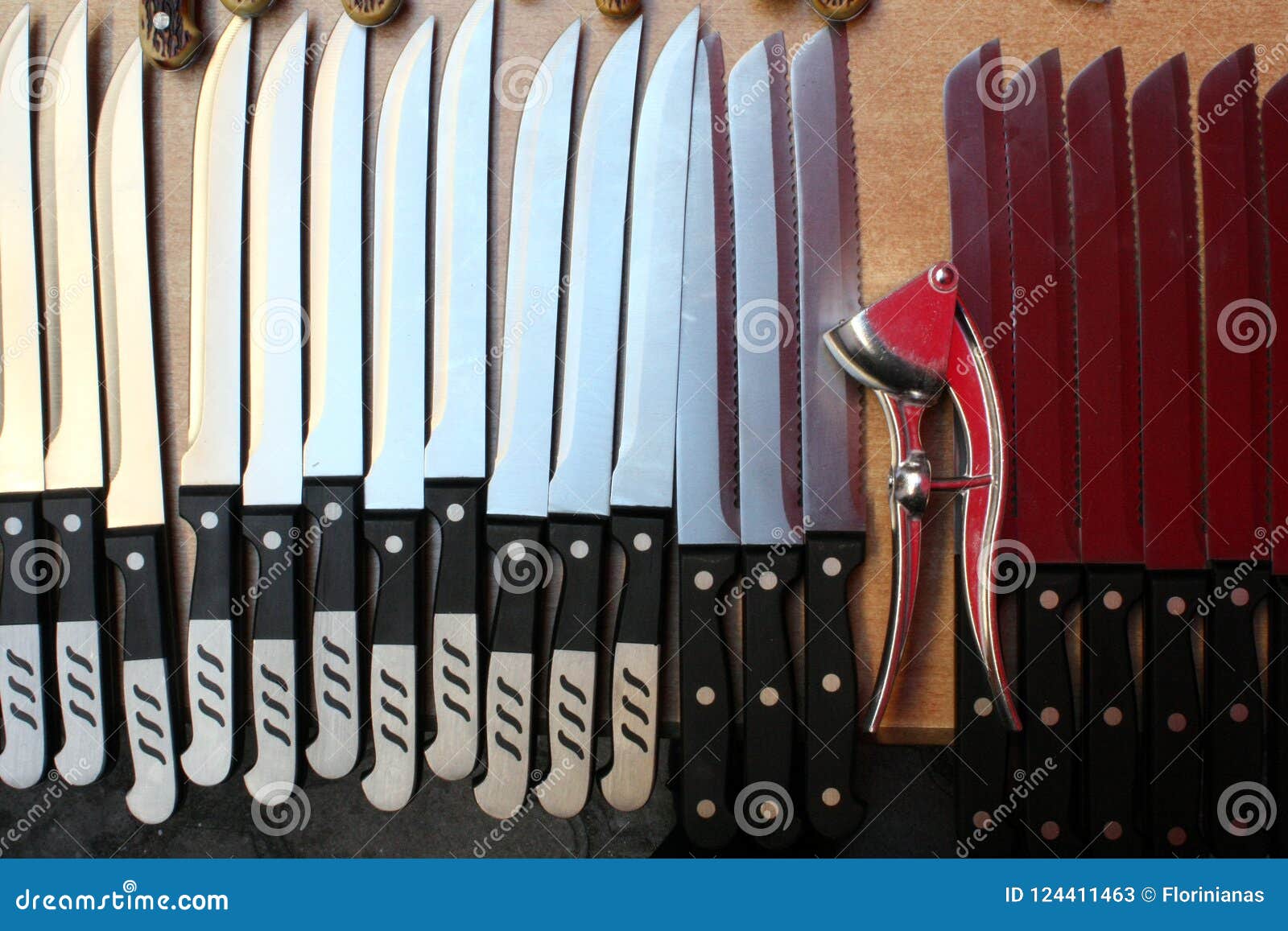 Knives in a Row Creating a Rhythm Broken by the Garlic Press Stock