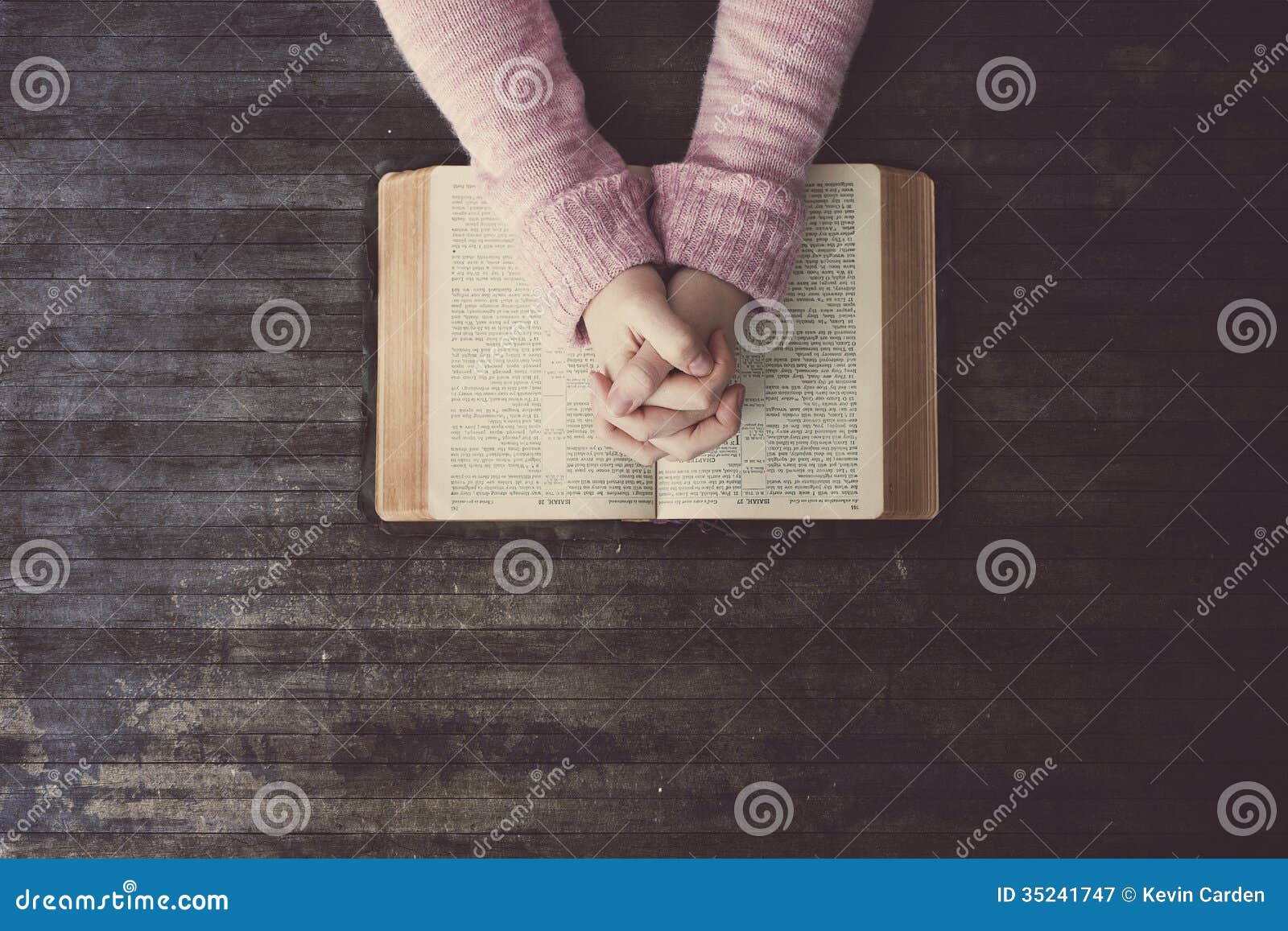 Kobiety modlenie na stole. Kobieta ono modli się nad biblią na drewnianym stole.