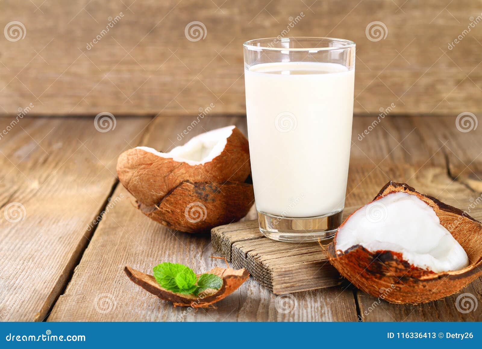Kokosowy i kokosowy mleko w szkle, mennica na drewnianym starym stole