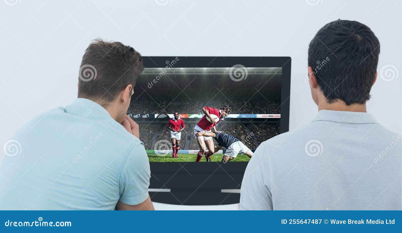 Komposition Zweier Männlicher Sportfans, Die Rugby-Spiel Auf TV Sehen Stockbild