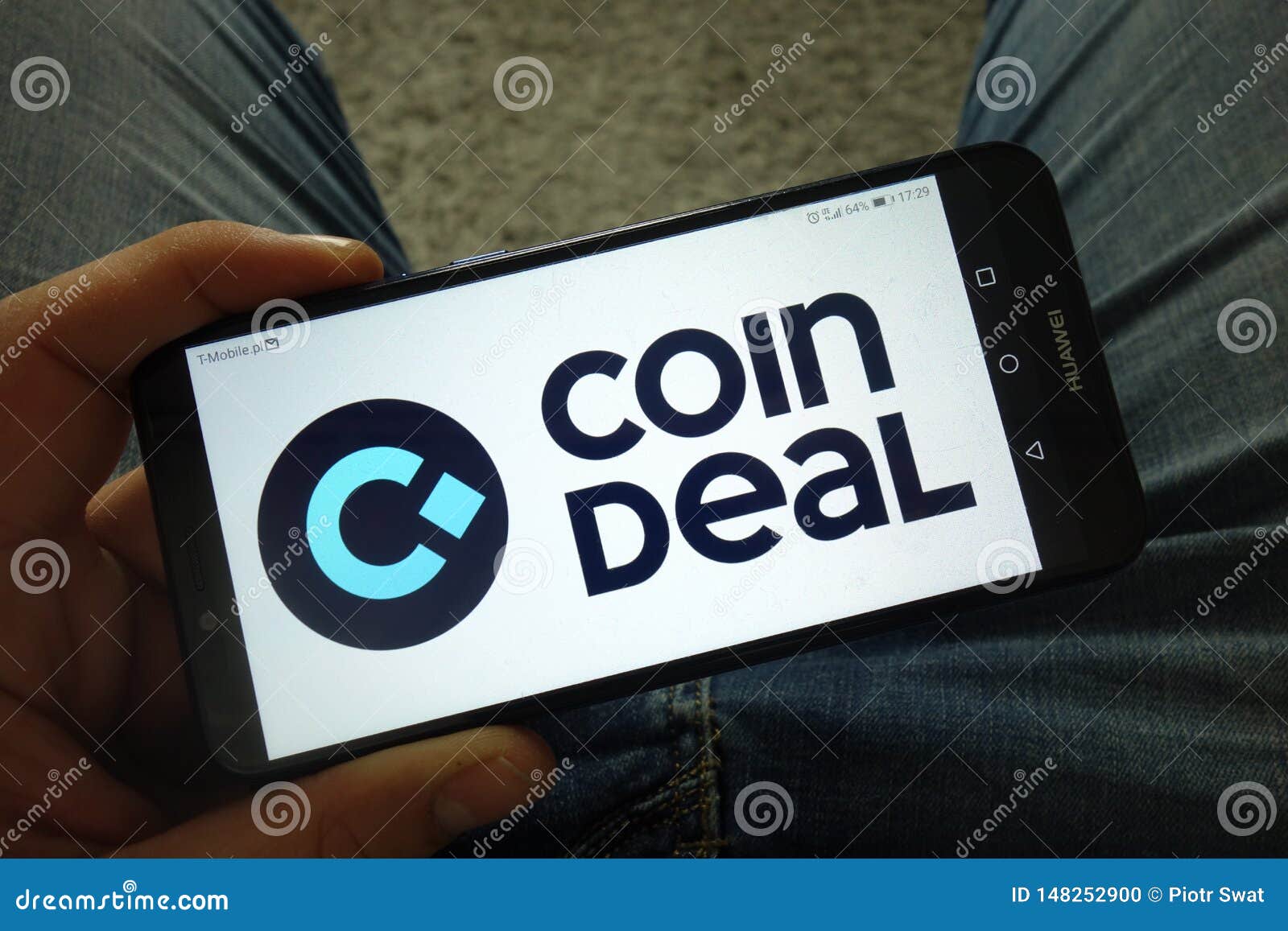 Man Holding Smartphone With Coindeal Cryptocurrency Exchange Logo