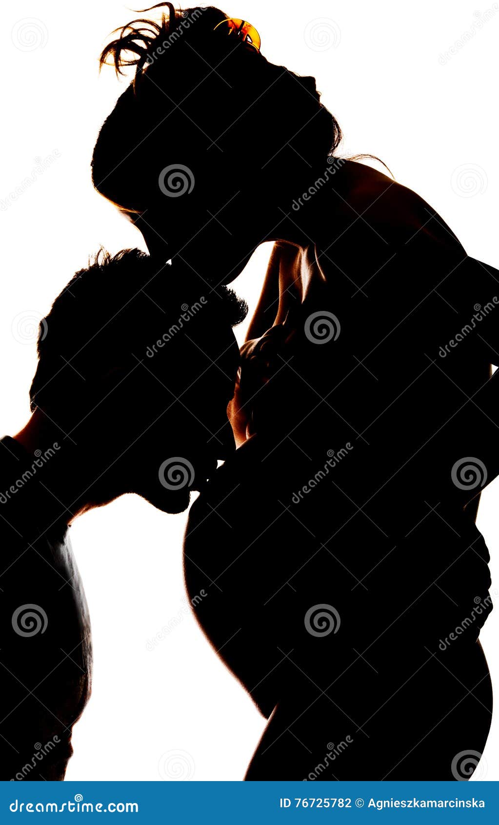 Kontur av en yong män som kysser buken av hans gravida fru