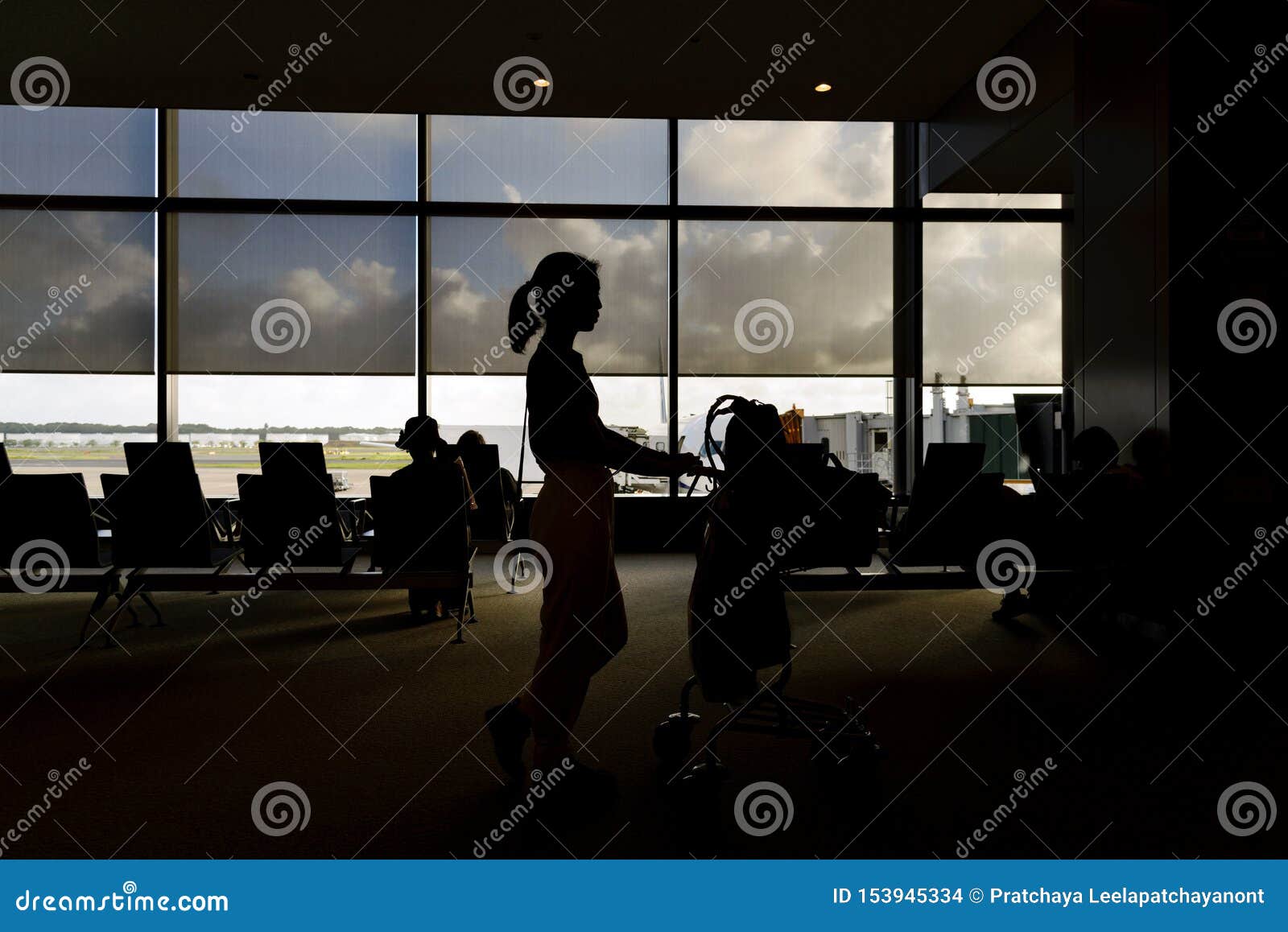 Konturer av kvinnan med bagagevagnar i flygplatsavvikelsevardagsrum