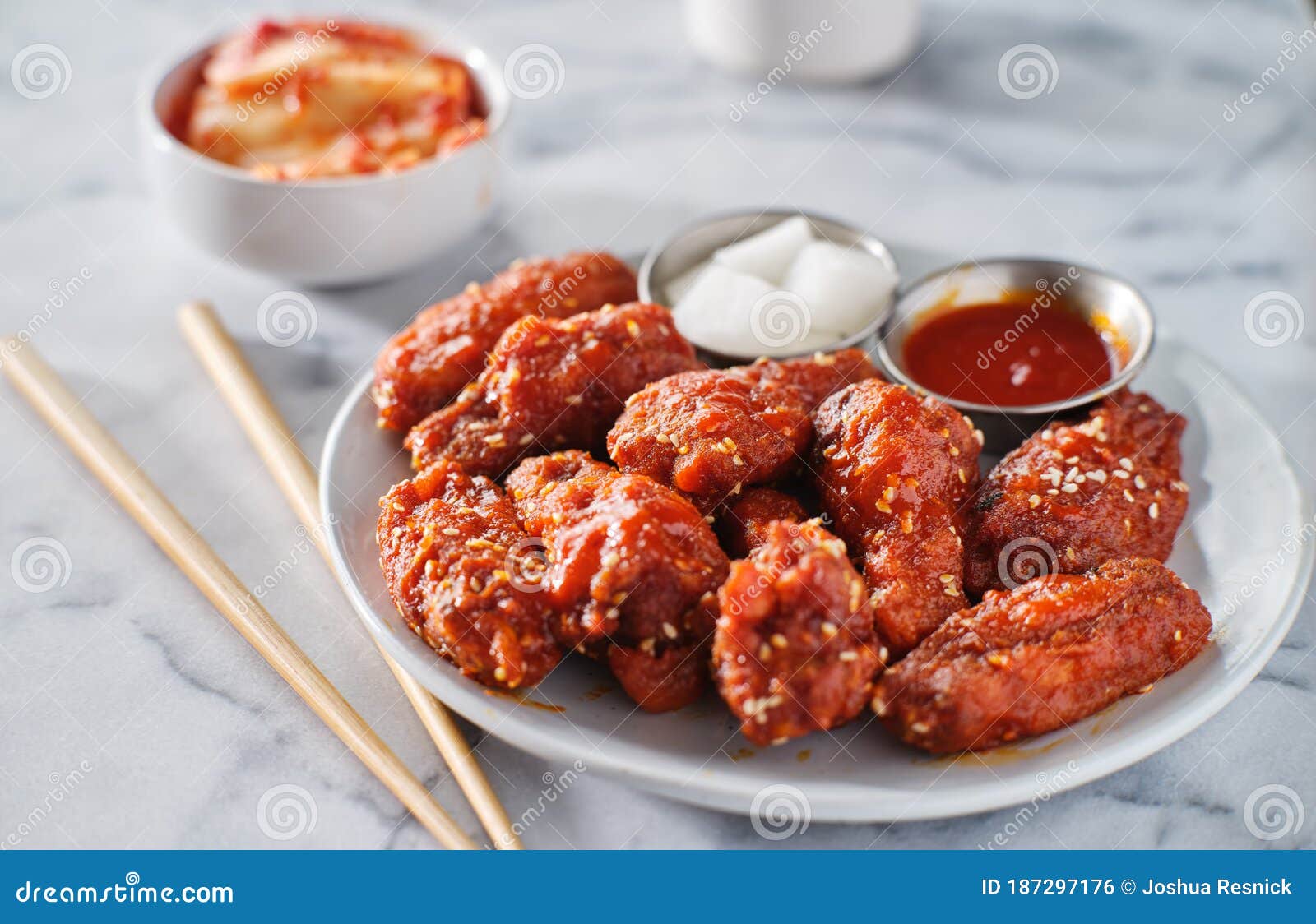 korean chicken wings in gochujang sauce with kimchi and pickled radish