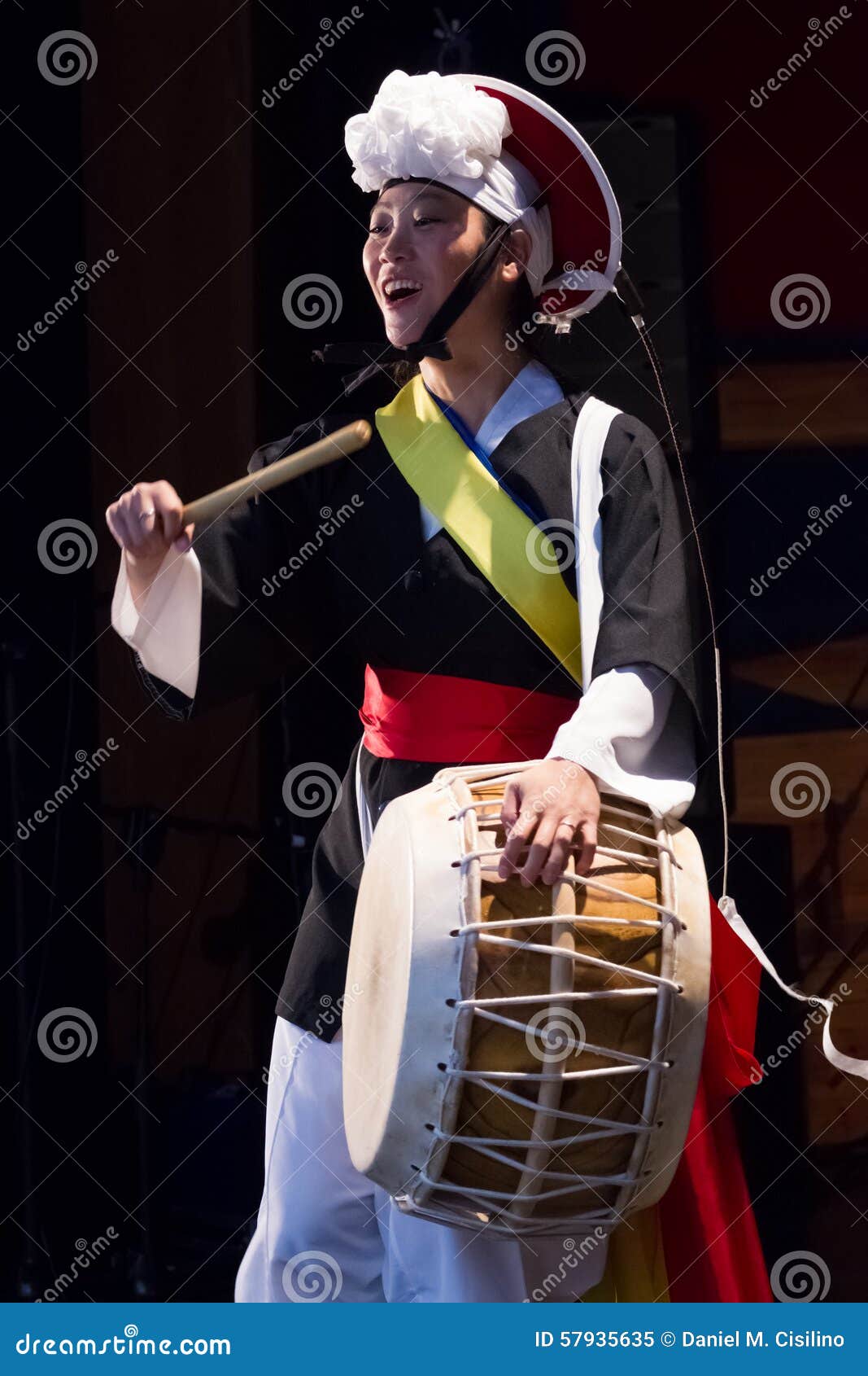 A female korean musician playing traditional percussion music (samulnori) i...