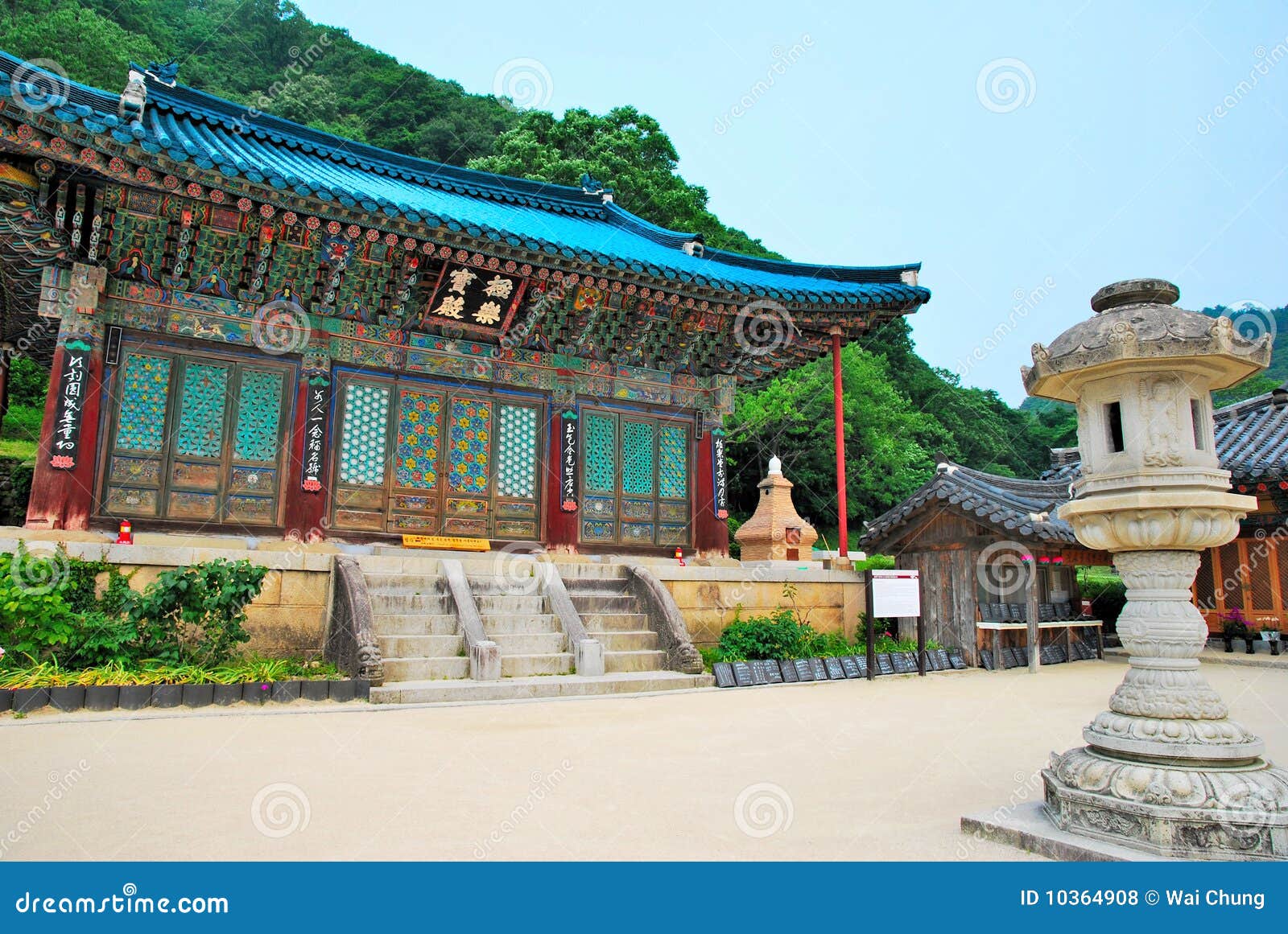 Korean temple architecture. Korean-styled detailed architecture of the main building and stone lantern in the foreground