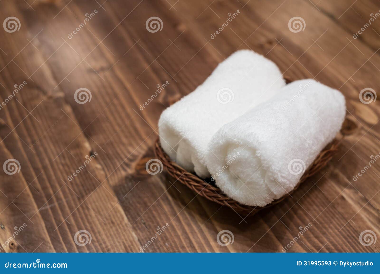 Korg av rena vita handdukar på trätabellen