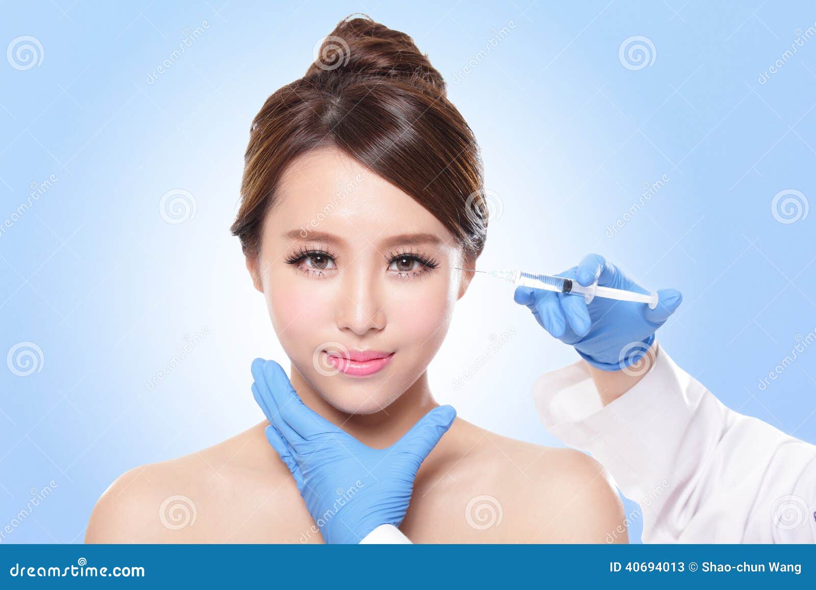 Sluit omhoog van kosmetische injectie aan het mooie vrouwengezicht Geïsoleerd op blauwe Aziatische achtergrond,
