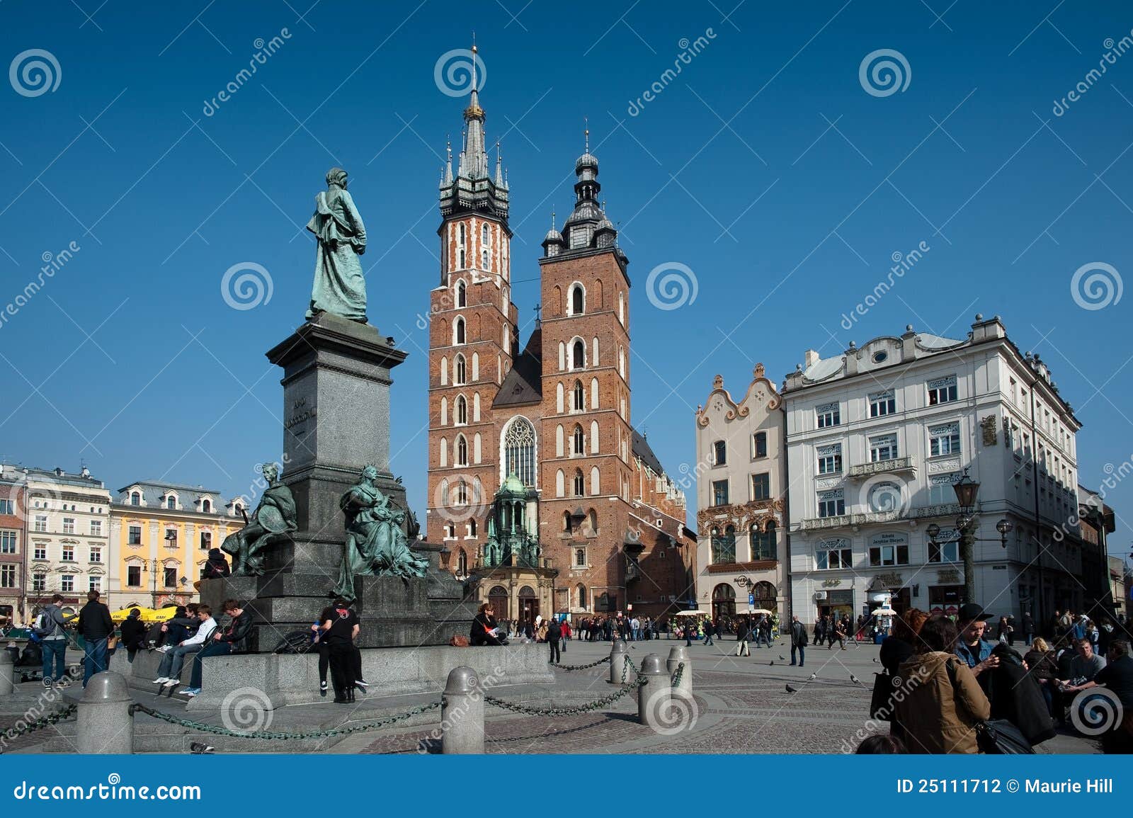 Krakow gammal fyrkantig town. Ci för den adam bronskyrkan fyllde townen för turister för gator för statyn för mickiewicz för den förgrundskokrakow mariackien den gammala