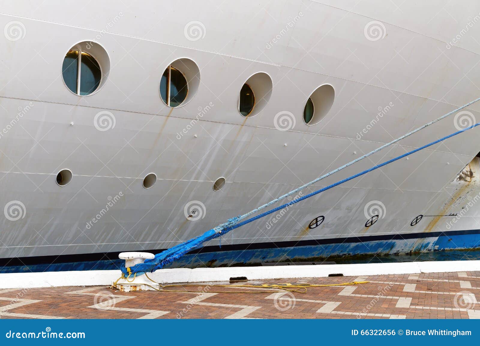 Kreuzschiff festgemacht am Dock. Weißes Kreuzschiff mit den runden Öffnungen, festgemacht zum Dock mit blauem Seil