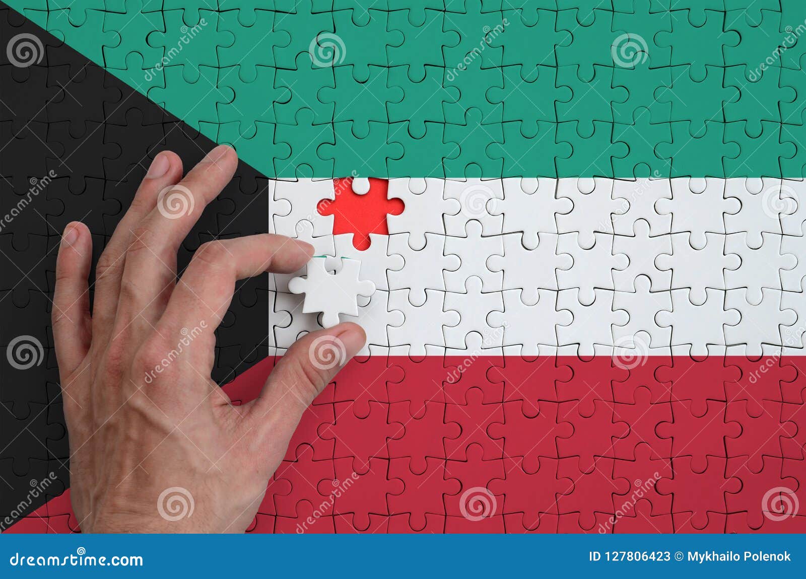 Kuwait Flag is Depicted on a Puzzle, Which the Man`s Hand Completes To
