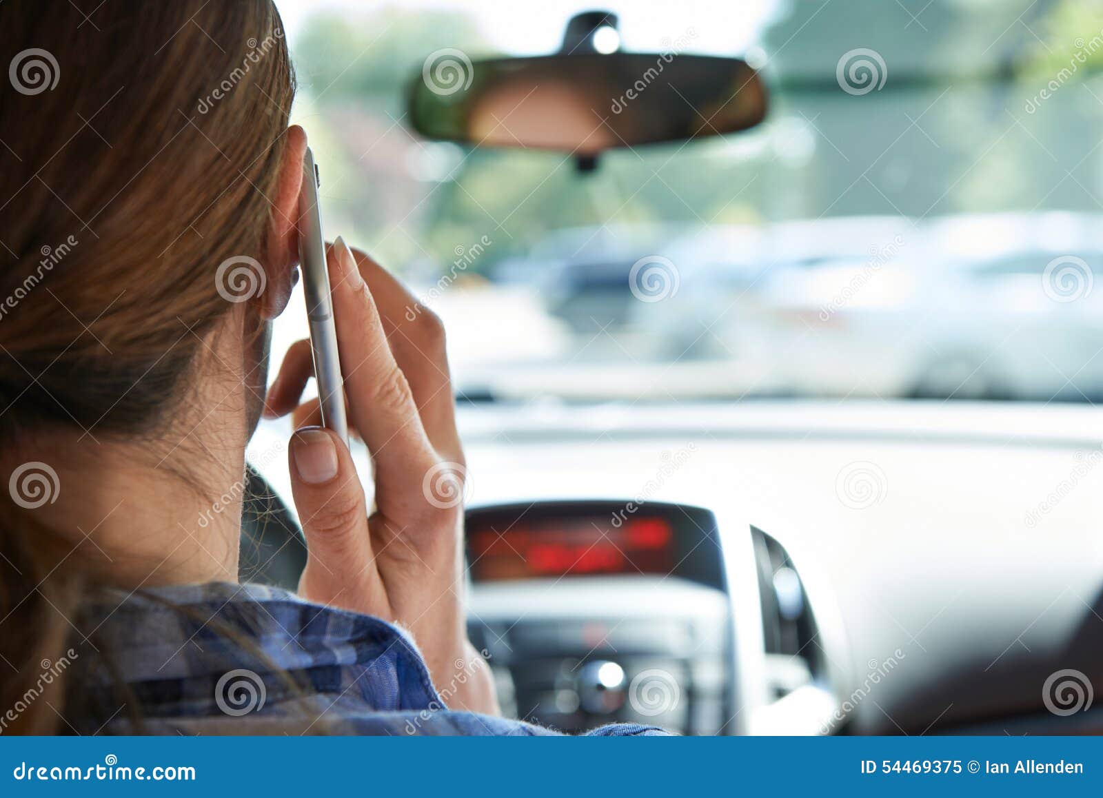 Kvinna i bil som talar på mobiltelefonstundkörning