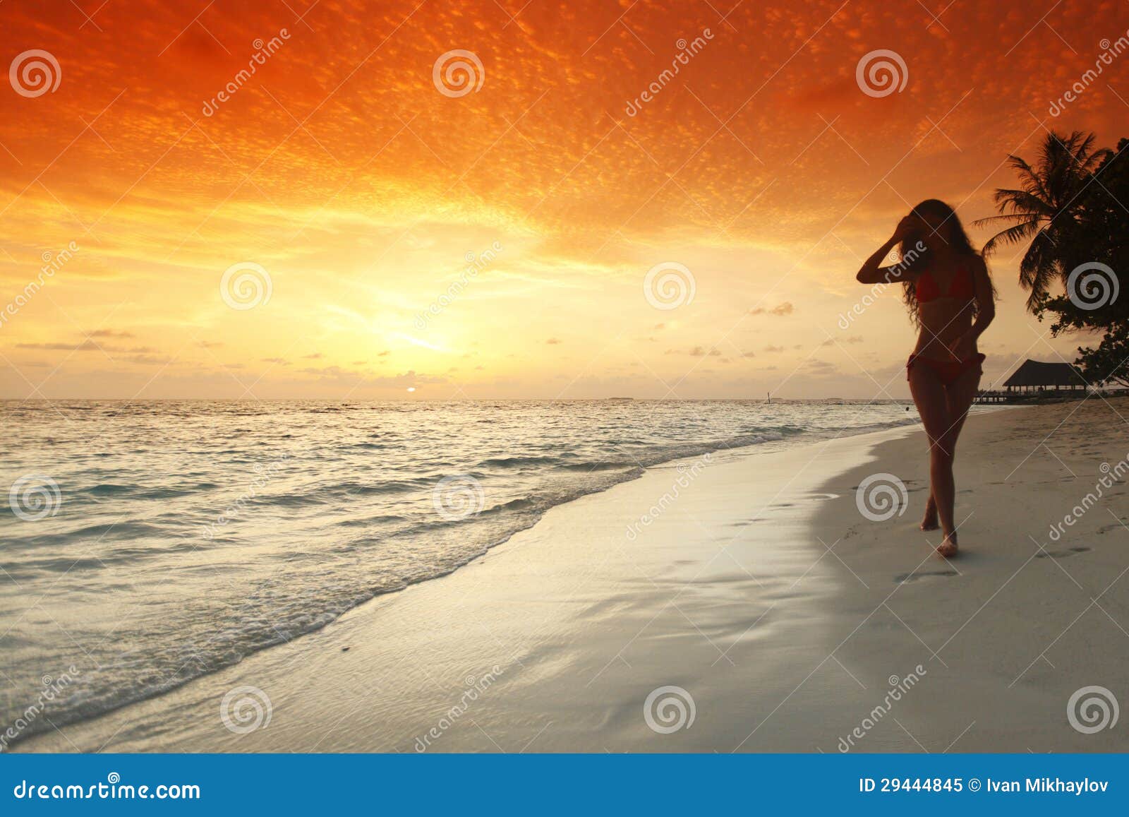 Kvinna som går på strand. Ung kvinna som lätt går på strand under solnedgång