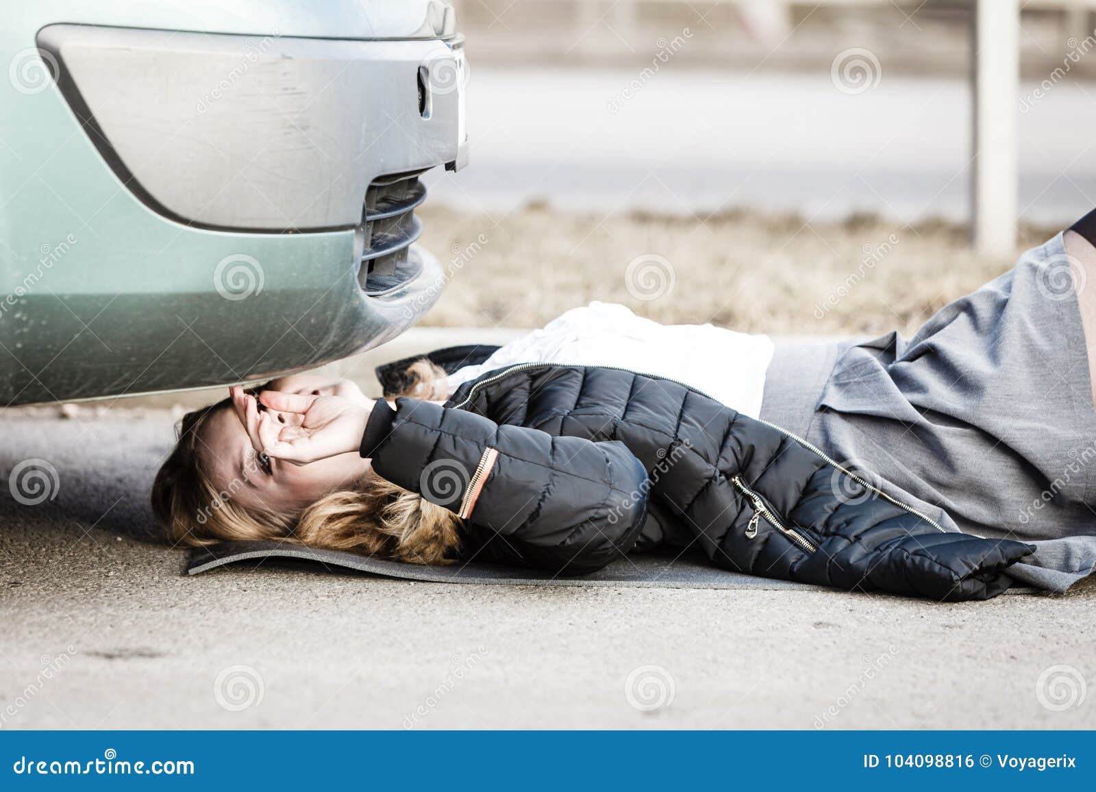 Женщина разбила машину. Девушка лежит под машиной. Фотографировать лёжа автомобиль.