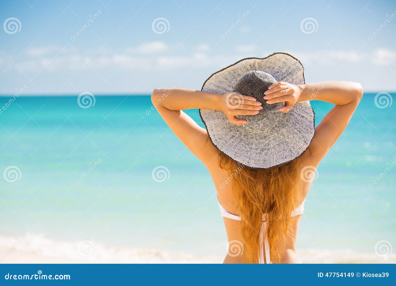 Lycklig ung kvinna som tycker om att koppla av för strand som är glat i sommar vid tropiskt blått vatten Härlig bikinimodell som är lycklig på för strandsol för lopp den bärande hatten på Rolig semester för strand, loppbegrepp