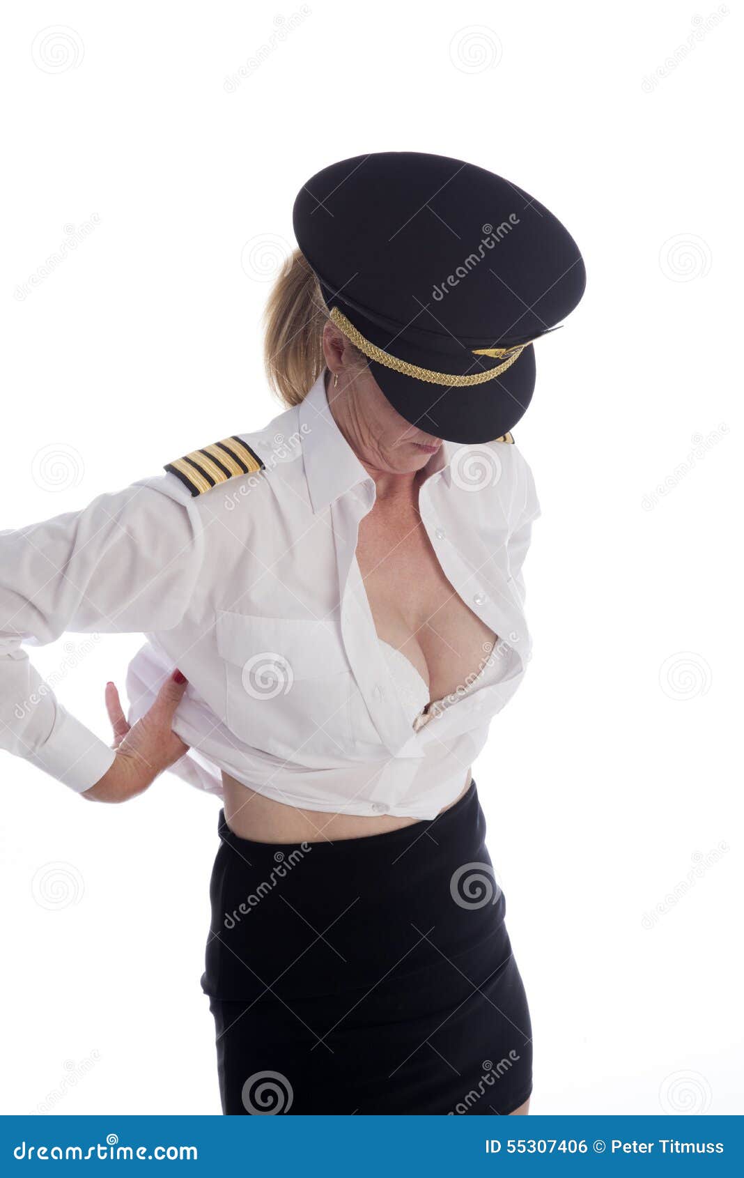 Kvinnlig flygbesättningsman som får klädd. Pilot- få för attraktivt kvinnligt flygbolag klätt och avslöjande av hennes dekolletage
