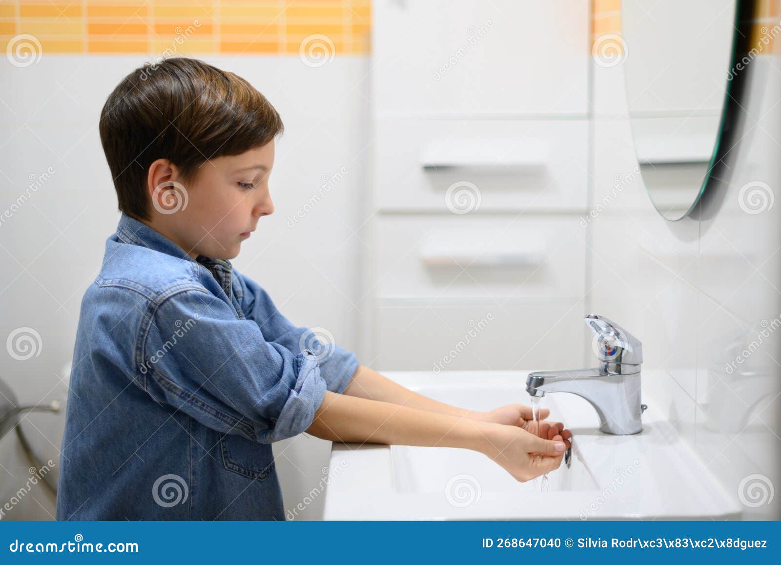 L'enfant Allume Le Robinet D'eau Dans La Salle De Toilettes Photo stock -  Image du santé, hygiène: 268647040