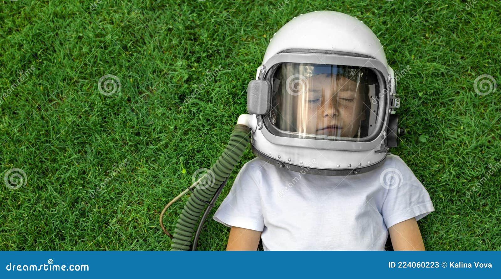 L'enfant Est Allongé Sur L'herbe Avec Un Casque Astronaute Et Rêve