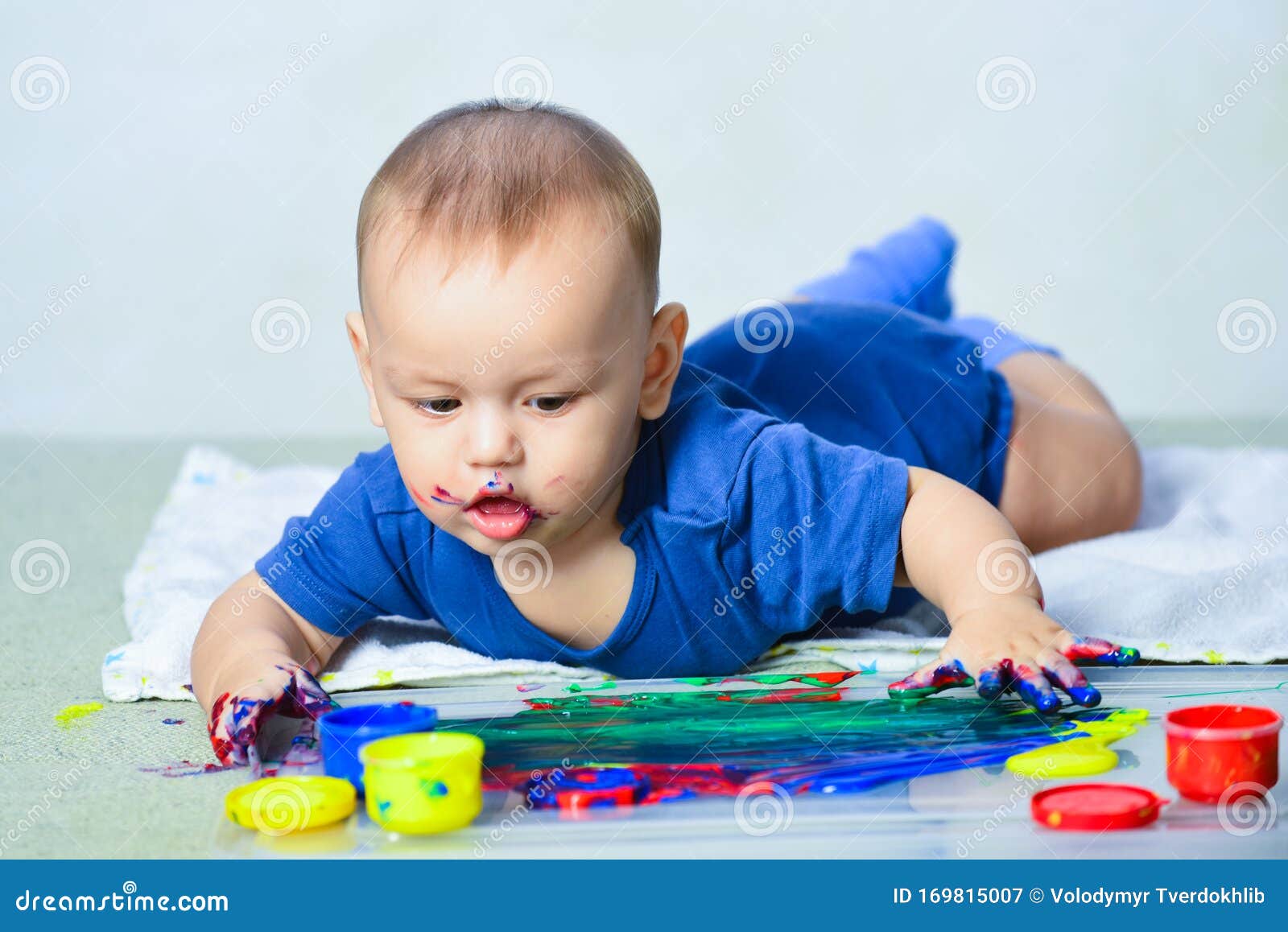 L'enfant Heureux De Bébé Dessine Avec Des Mains De Peintures