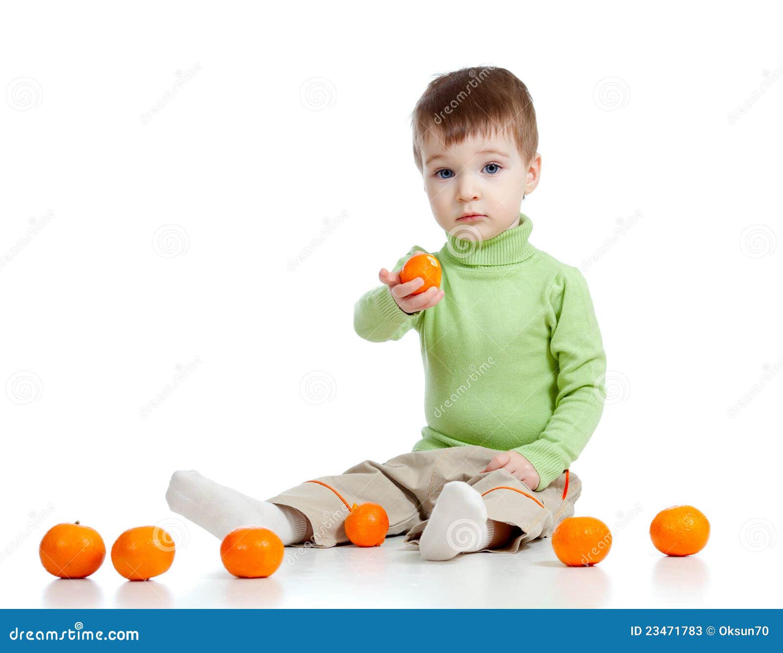 L'enfant offre à des fruits la nourriture saine. L'enfant offre à des fruits la mandarine saine de nourriture