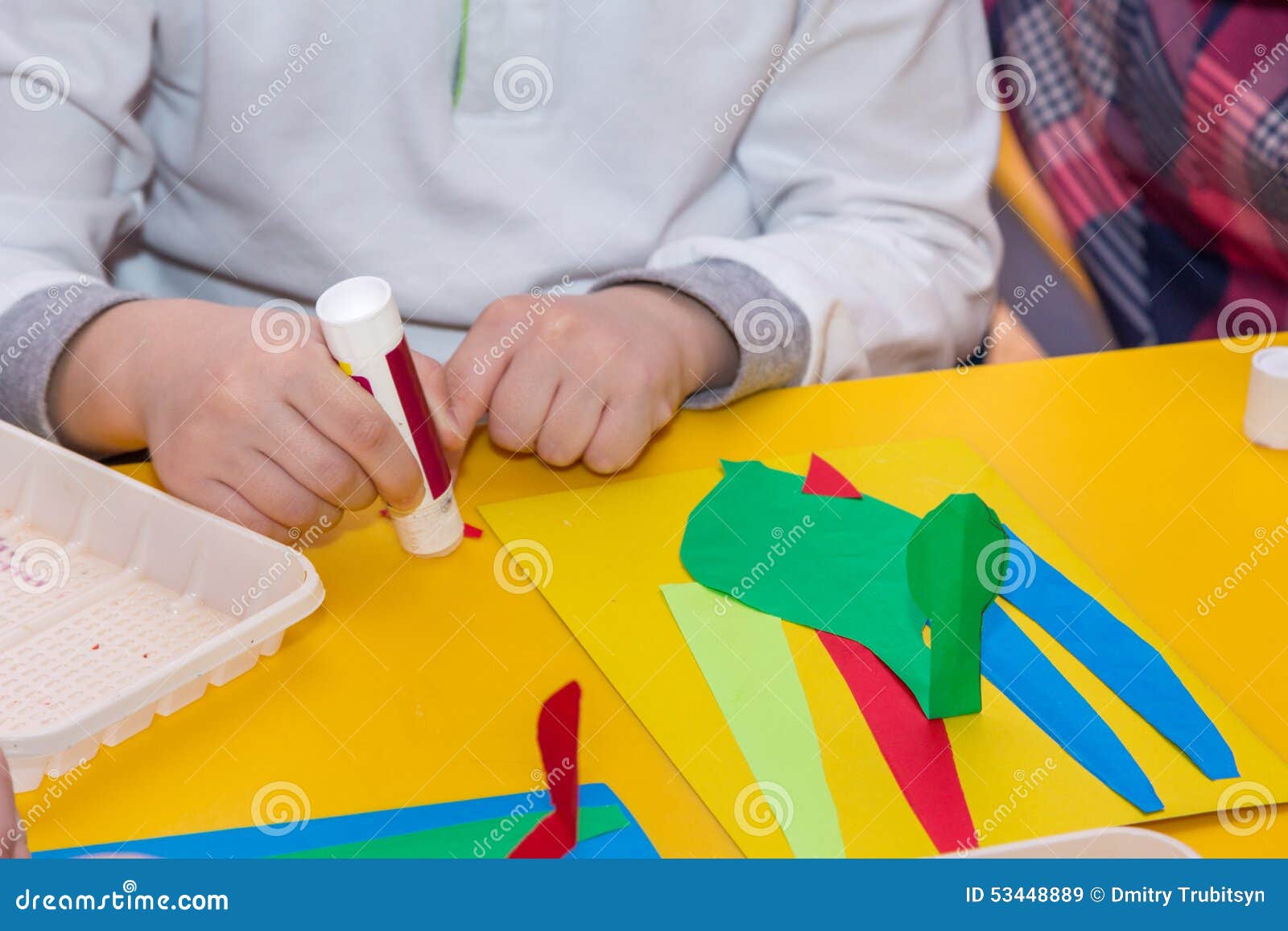 élève enfant fille avec du papier et de la colle faisant des