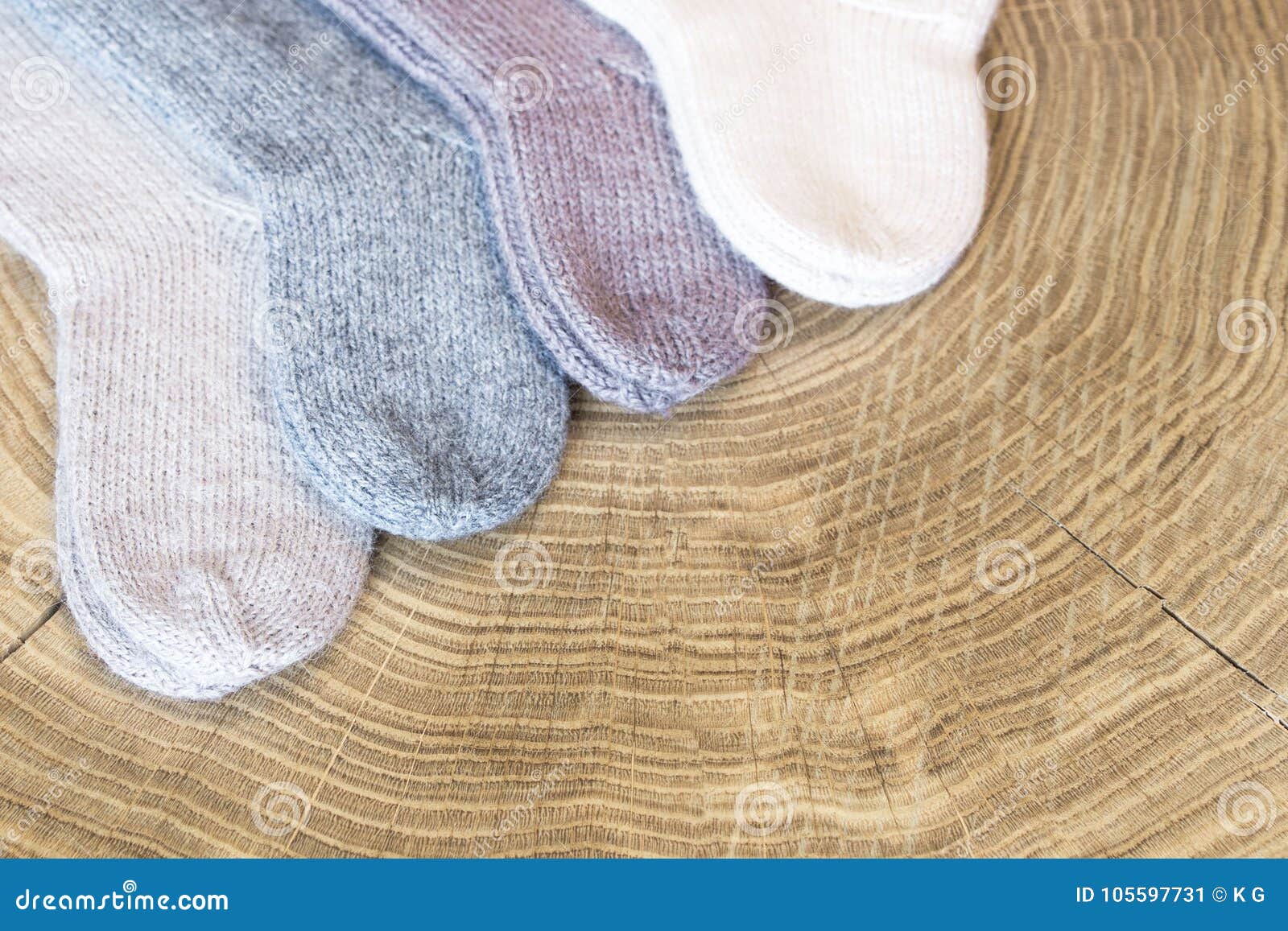 L'ensemble de petit cachemire coloré différent mignon a tricoté les chaussettes nouveau-nées de bébé sur un fond en bois de bureau