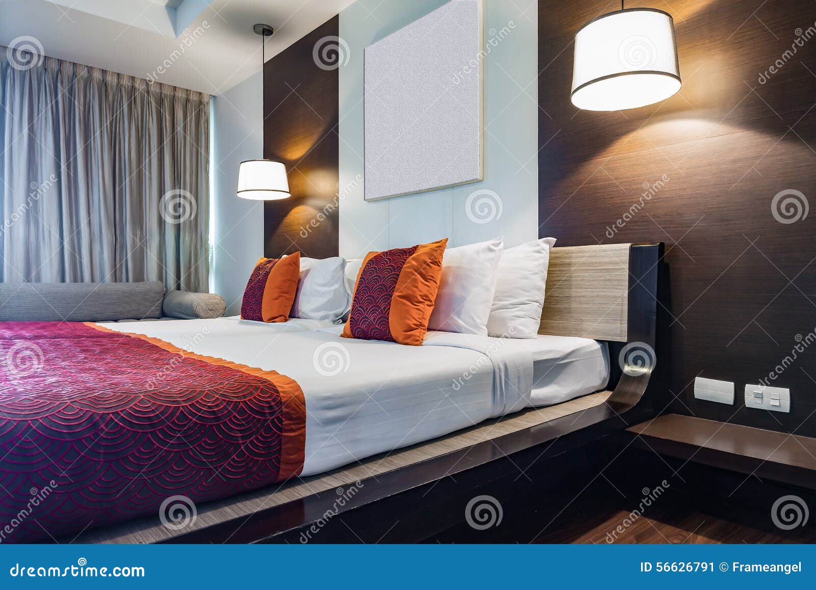 L'oreiller rouge sur la double chambre à coucher avec le drap ...