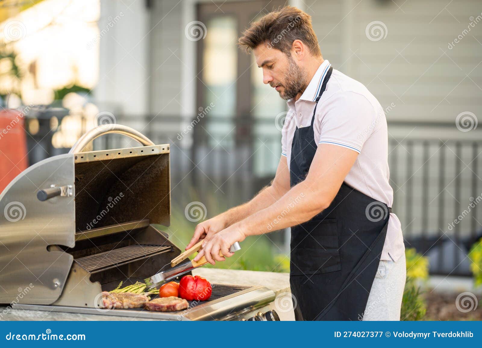 L'uomo Cucina Carne Su Barbecue Nel Cortile Della Casa. Bell'uomo Che  Prepara Il Barbecue. Capo Barbecue. Entrare Immagine Stock - Immagine di  svago, griglia: 274027377