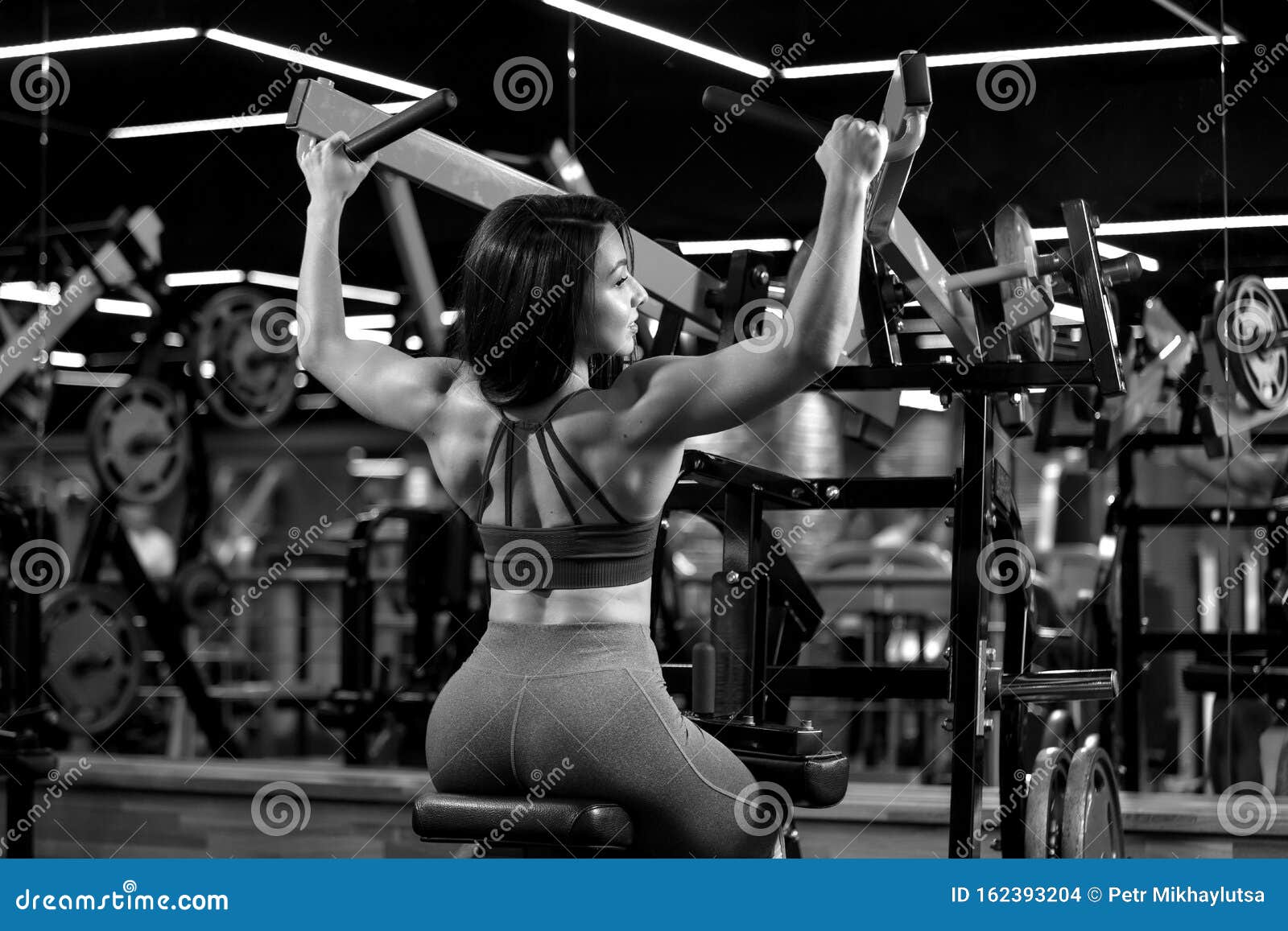 Una Chica Sexy Del Gimnasio EstÃ¡ Sentada Haciendo Ejercicios De Hombro En  El Entrenador Imagen de archivo - Imagen de deporte, hermoso: 159993995