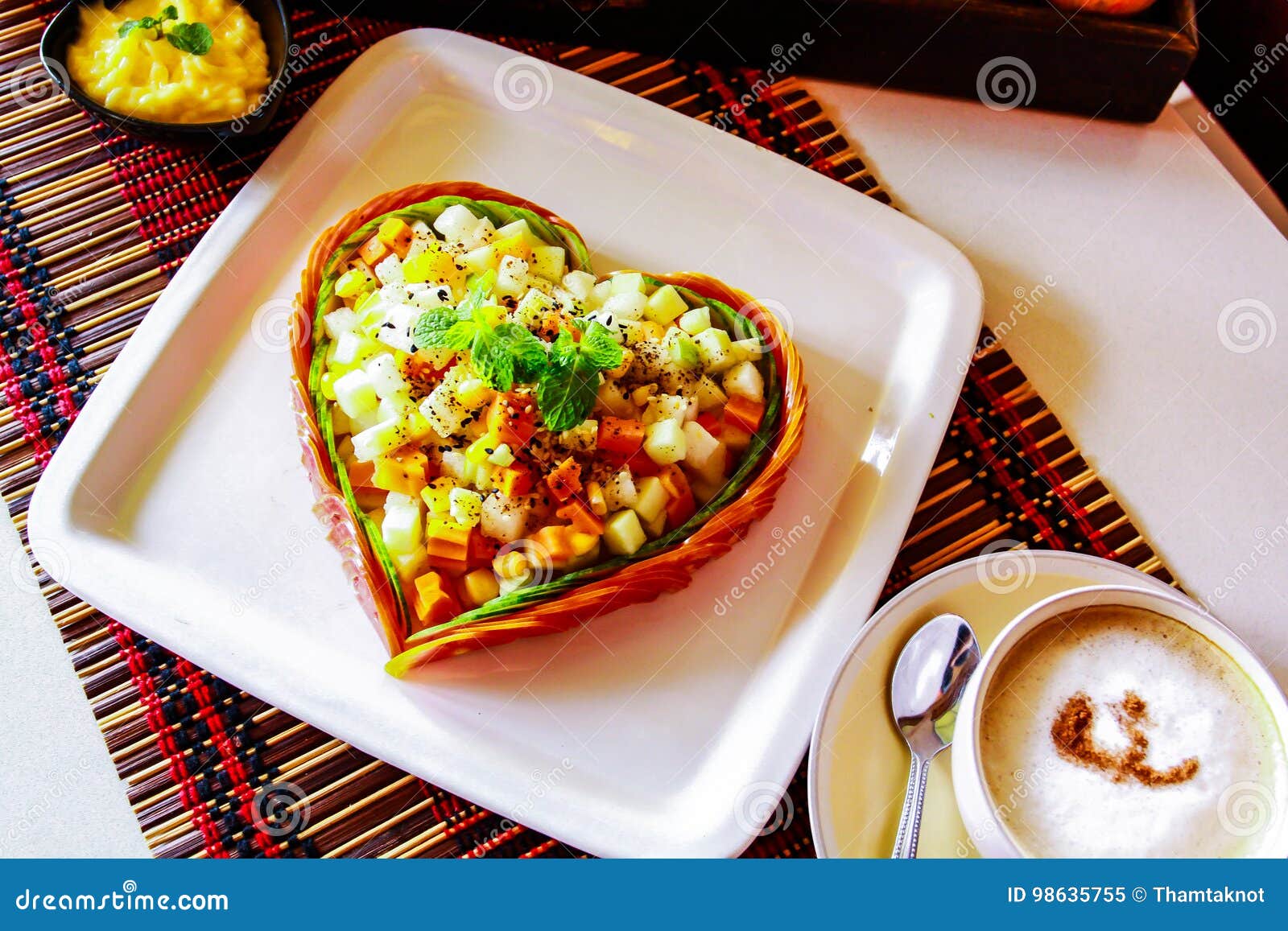 La ensalada de fruta se arregla como pozo en forma de corazón de la placa. La ensalada de fruta se coloca para formar un corazón en una placa también