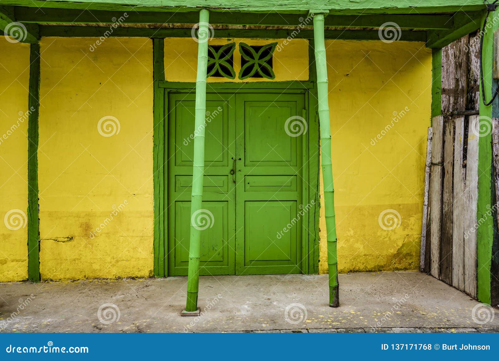 la entrade, ecuador - september 14, 2018 - green door on yellow wall.