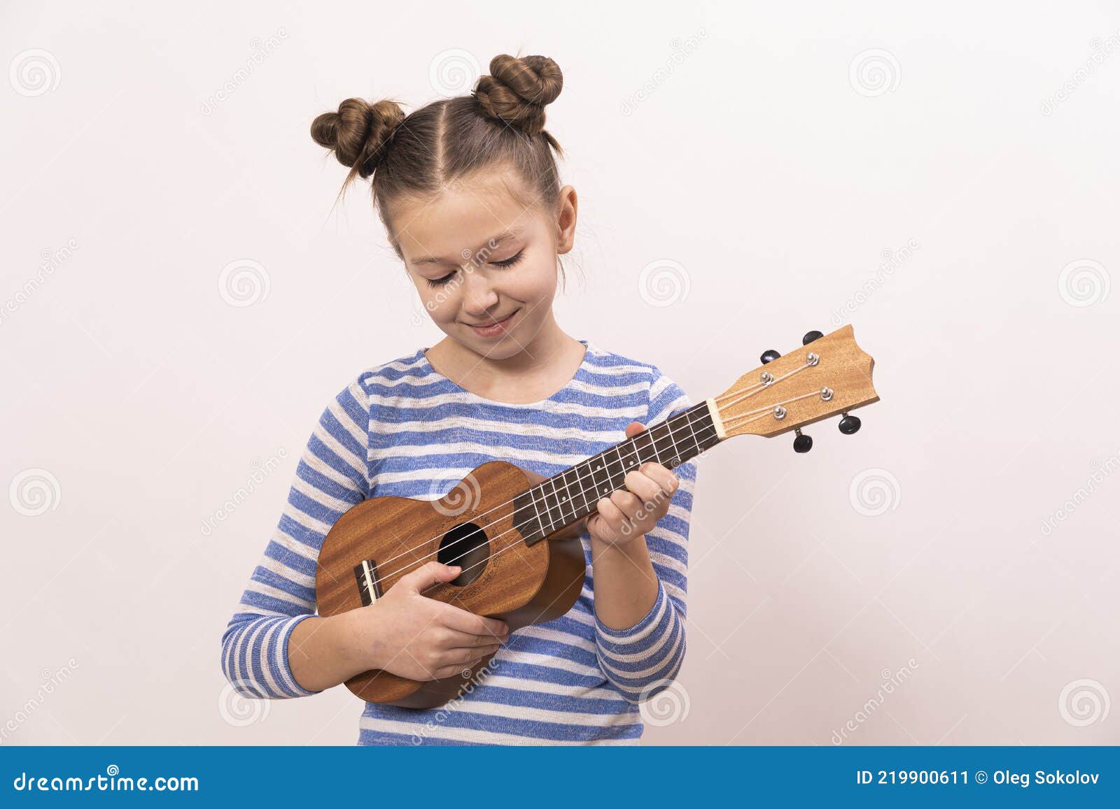 La Fille Chante Et Joue De L'ukulélé. L'enfant Rit Pose Pour La