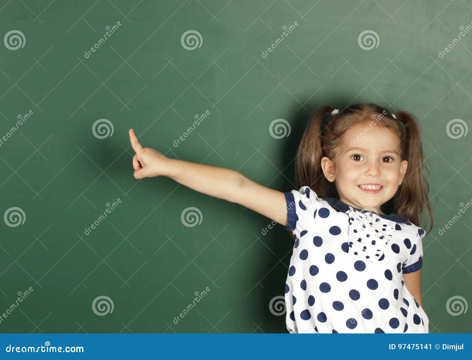 La Fille De Sourire D'enfant Montrent Avec Un Tableau Noir D'école
