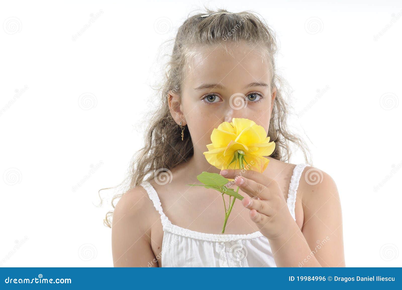 La fille sentant jaune s'est levée. Bel enfant blond sentant la fleur jaune