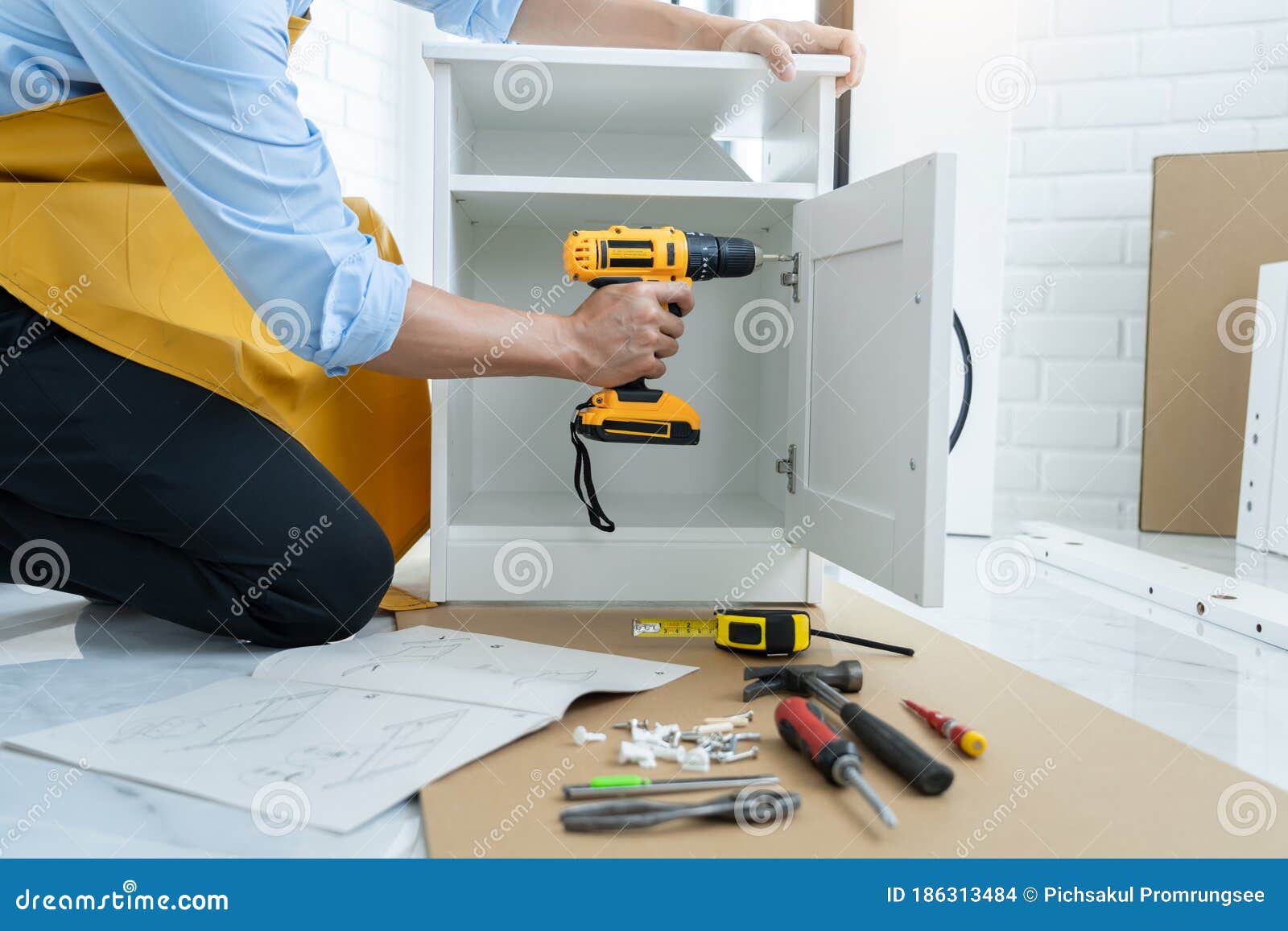 homme utilisant un tournevis sans fil assemblant des meubles à la maison,  charpentier travaillant avec un tournevis électrique sur le travail  25498776 Photo de stock chez Vecteezy