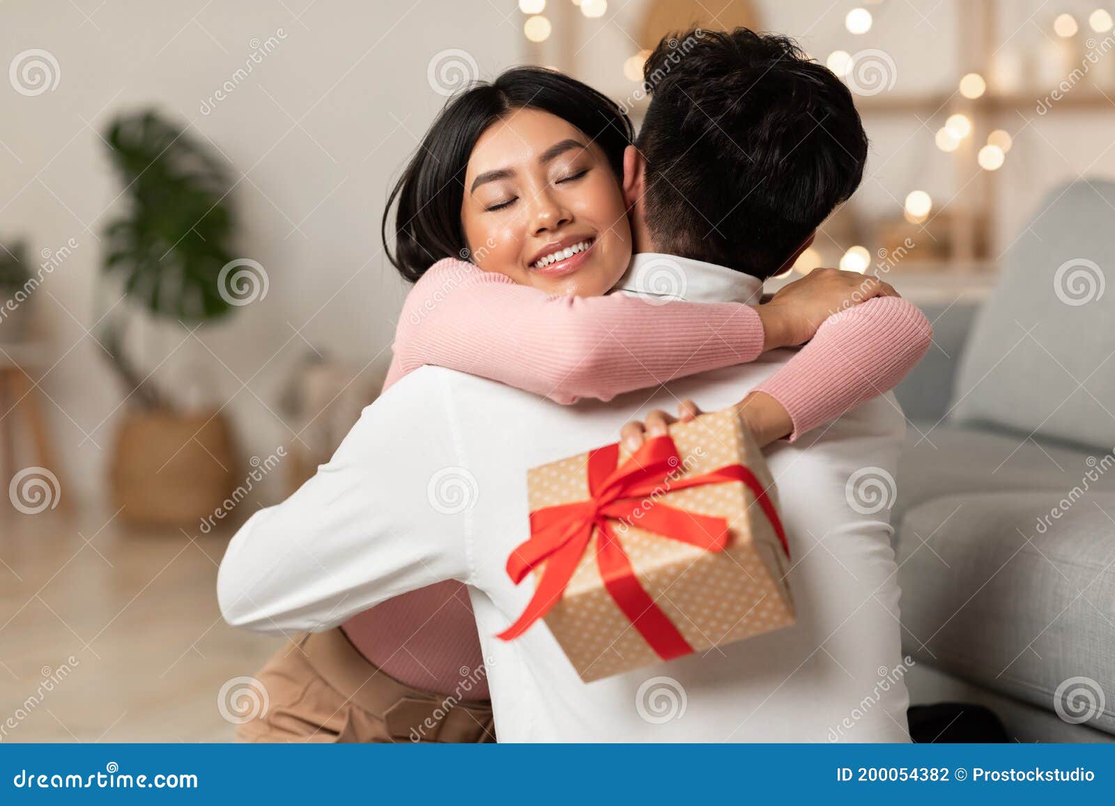 La Gioia Della Moglie Asiatica Con Il Marito Che Riceve Il Regalo Di Natale  a Casa Fotografia Stock - Immagine di tenuta, fidanzata: 200054382