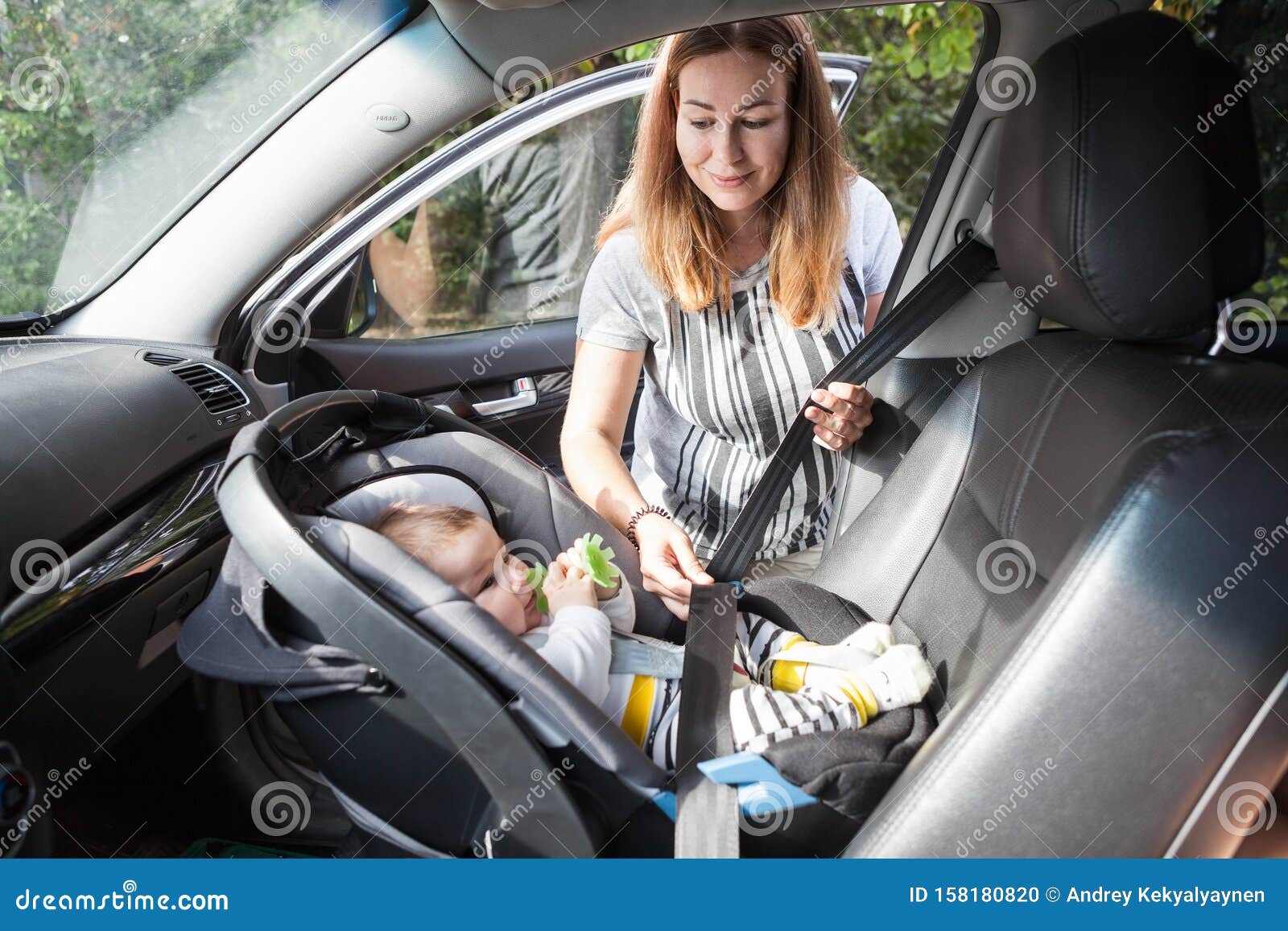 La Mère Attache Le Siège De Sécurité De L'enfant Avec Son Petit Bébé Sur Le  Siège Du Passager Avant, Le Bébé Est Assis Avec Son D Photo stock - Image  du garantie