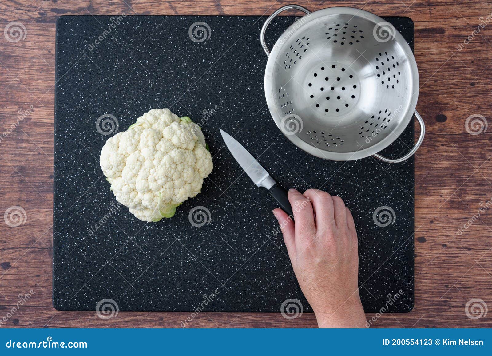 La Main De La Femme à La Tête Du Chou-fleur Sur Une Planche à Découper  Noire Sur Une Table, Un Couteau à éplucher Et Une Passoire Image stock -  Image du copie