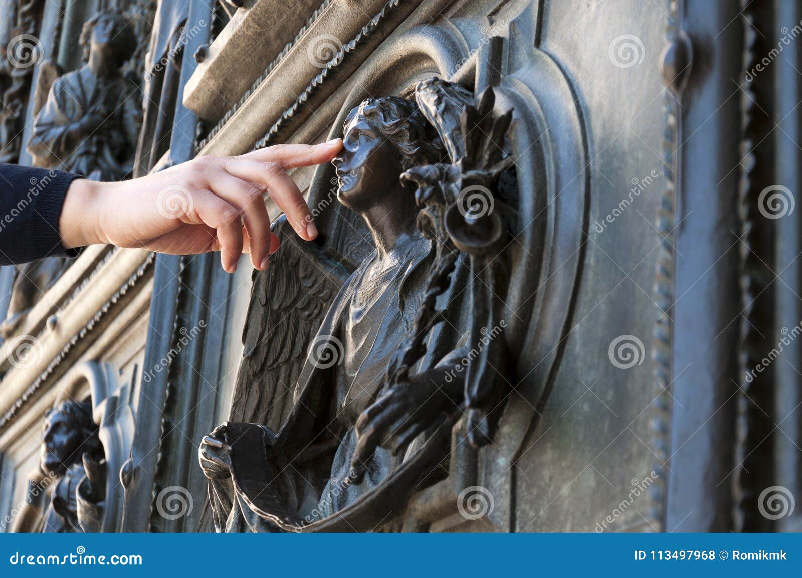 La Main Touche L'ange à La Porte De L'église De Duomo à Milan