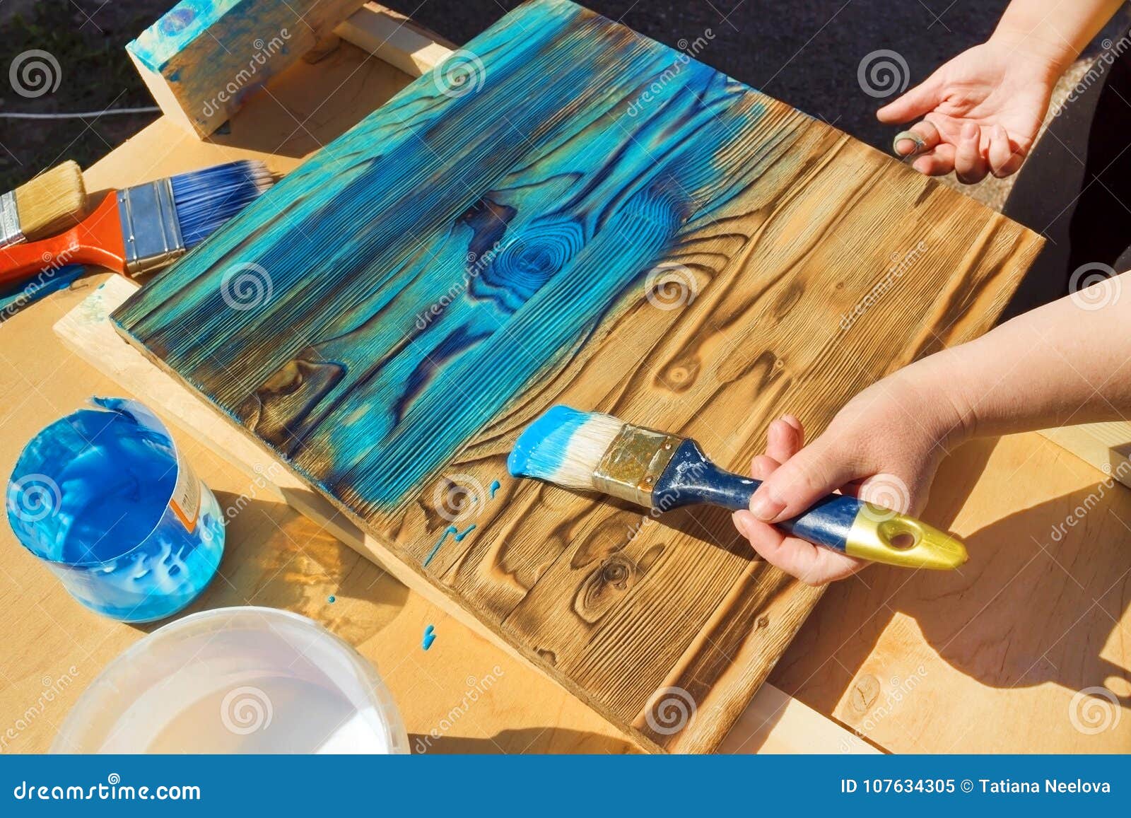 carrera Específico Quinto La Mano De Una Mujer Que Sostiene Un Cepillo De Acrílico, Pintando Un  Escritorio De Madera Con Color Azul En El Jardín Tiempo De Imagen de  archivo - Imagen de herramienta, blanco: