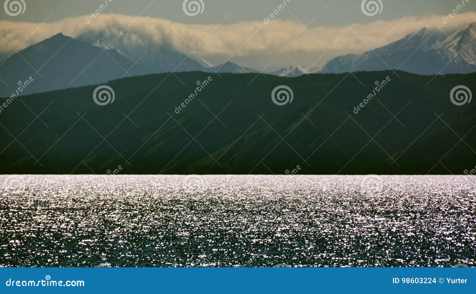 La Mongolie la soirée sur le rivage de l'horizon argenté d'étincelles de Hovsgol de lac, montagnes de Sayan la première neige pen. La Mongolie, pour voir le soir sur le rivage du nord du lac Hovsgol, l'argent de scintillement de l'eau, l'horizon, la première neige le 12 août 2017 Sayan, horizontalement