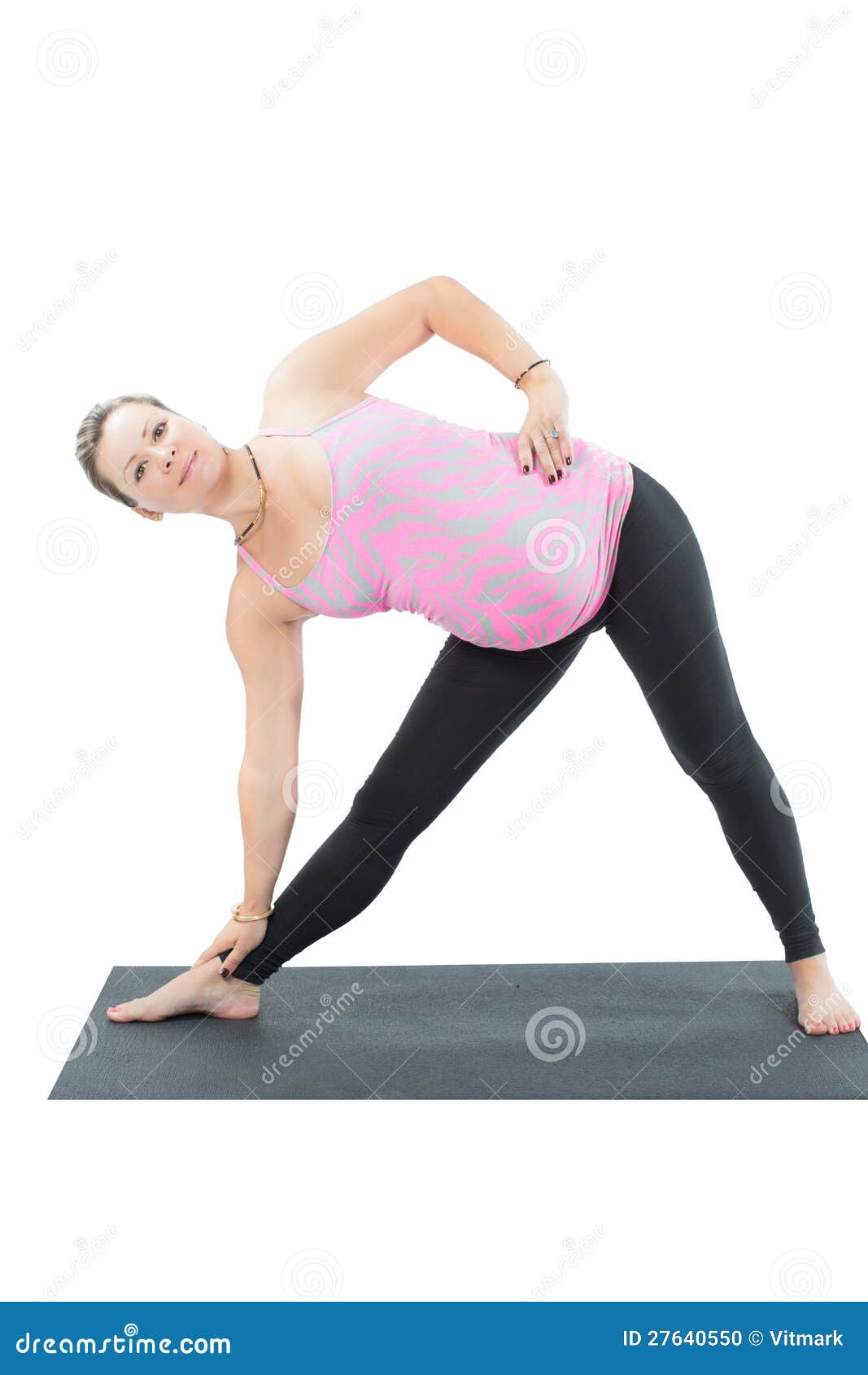 La mujer embarazada de la aptitud hace estiramiento en actitud de la yoga. La mujer embarazada de la aptitud hace que el estiramiento en yoga y pilates plantea en el fondo blanco el concepto de deporte y de salud