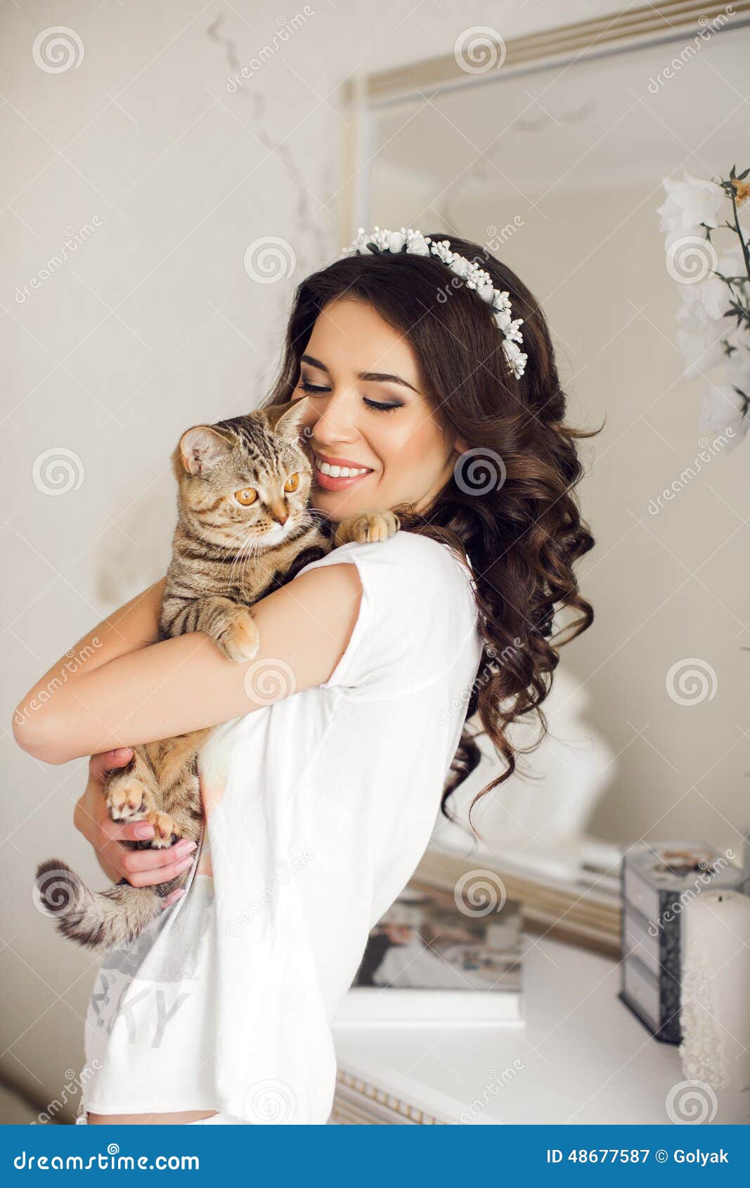 la-mujer-en-el-dormitorio-con-el-gato-en-sus-brazos-48677587.jpg
