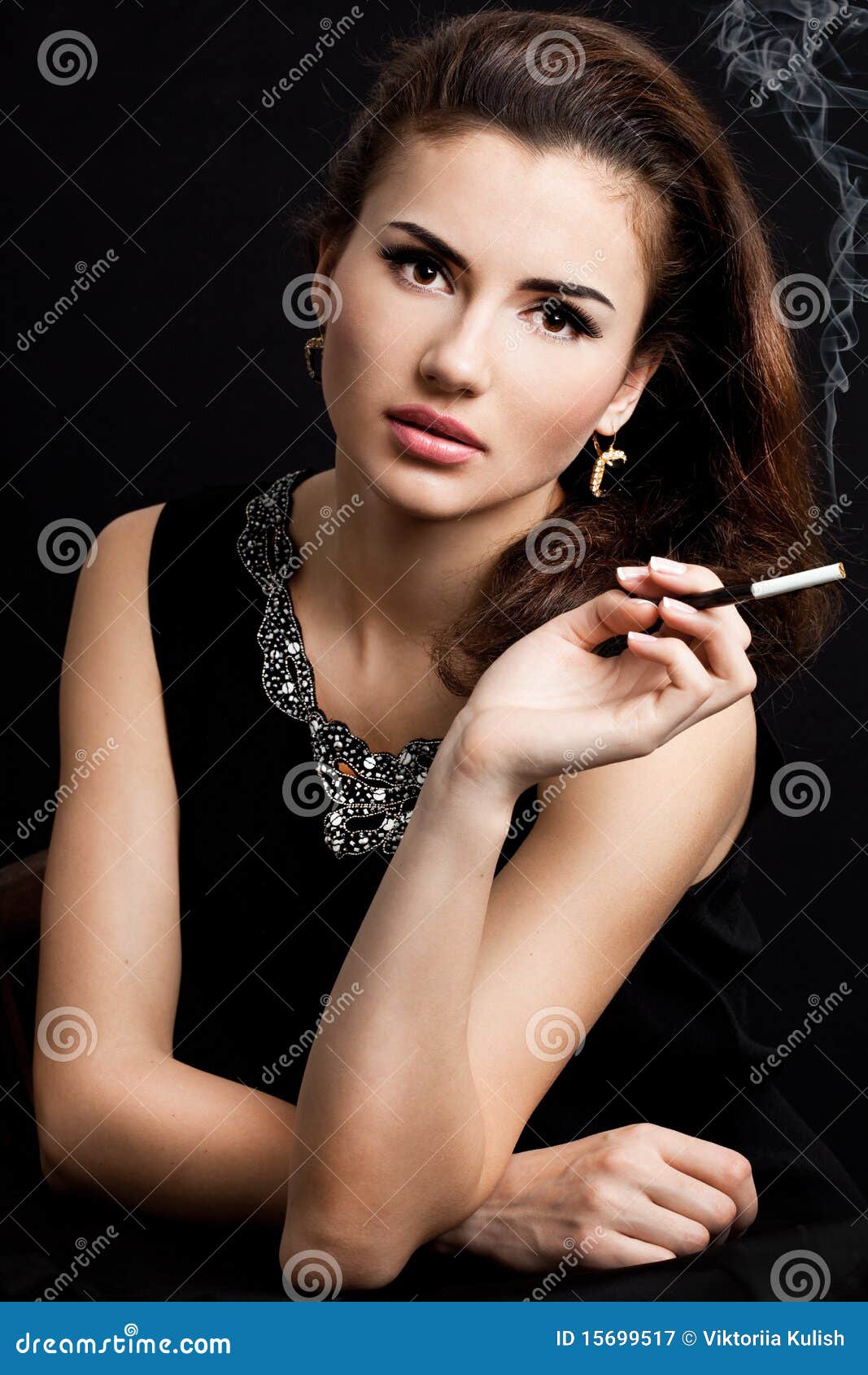 La mujer fuma un cigarrillo. La mujer hermosa fuma un cigarrillo