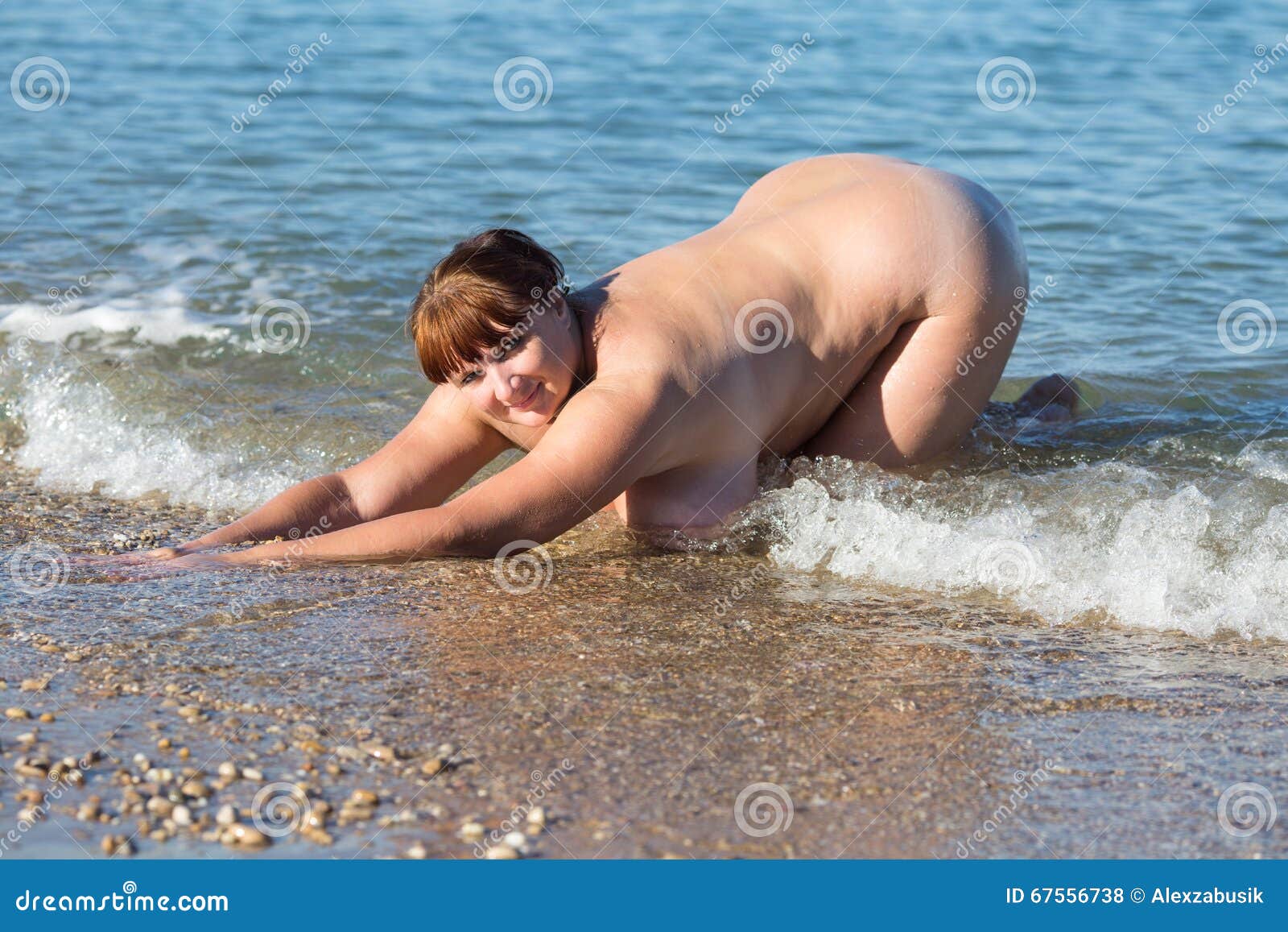 La Mujer Gorda Desnuda Se Arrodilla En El Borde De Las Aguas Foto de archivo